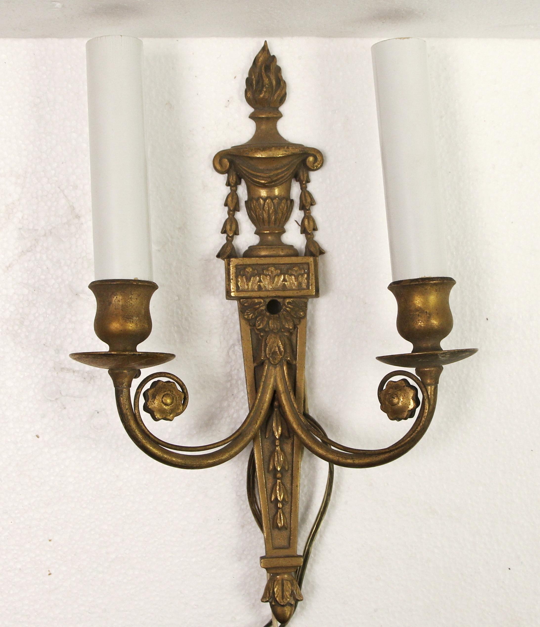 1970s touchier style bronze two candlestick arm sconces with torch detail. This can be seen at our 400 Gilligan St location in Scranton, PA. 