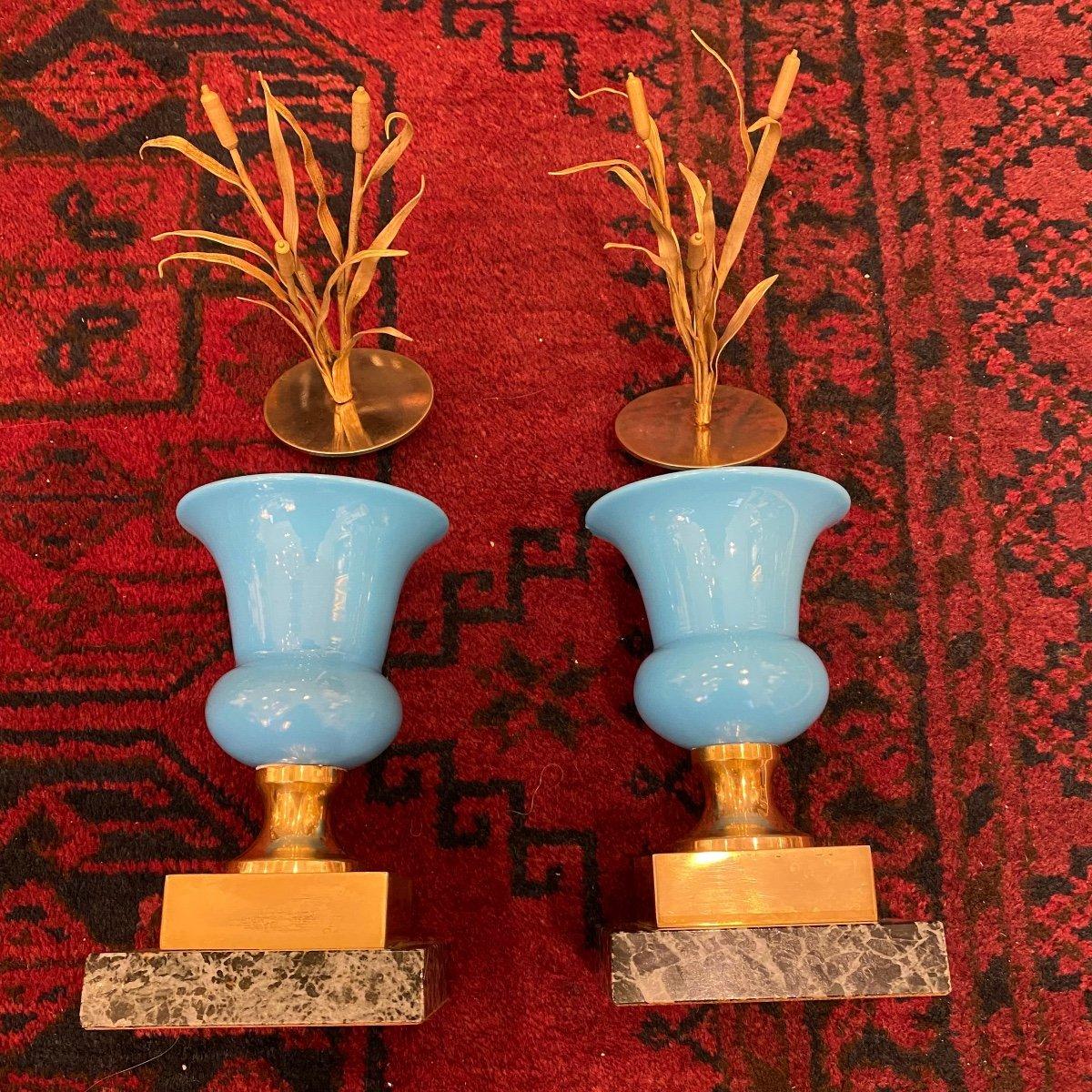 We present you with this lovely pair of covered vases in opaline glass with reed-adorned lids, set on socles. Dating back to the 1970s, these Medici-style vases in turquoise blue opaline evoke the style of the Charles X era. They stand on bases