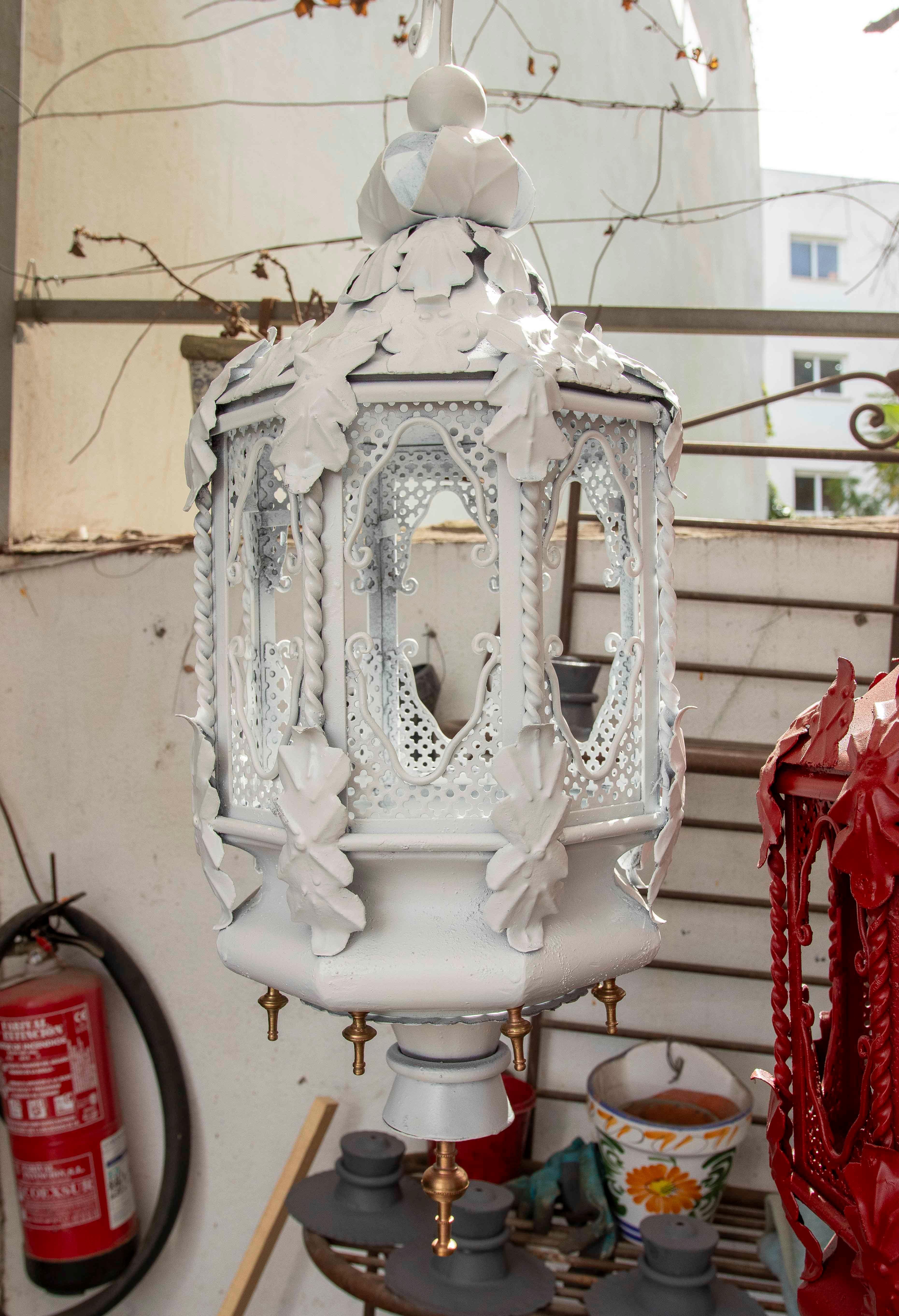 Ein Paar schmiedeeiserne Hängelampen, weiß lackiert und mit ornamentalen Details wie Blättern und durchbrochenen Mustern verziert. Sein klassisches und symmetrisches Design erinnert an den Vintage-Stil, ideal für rustikale oder romantische