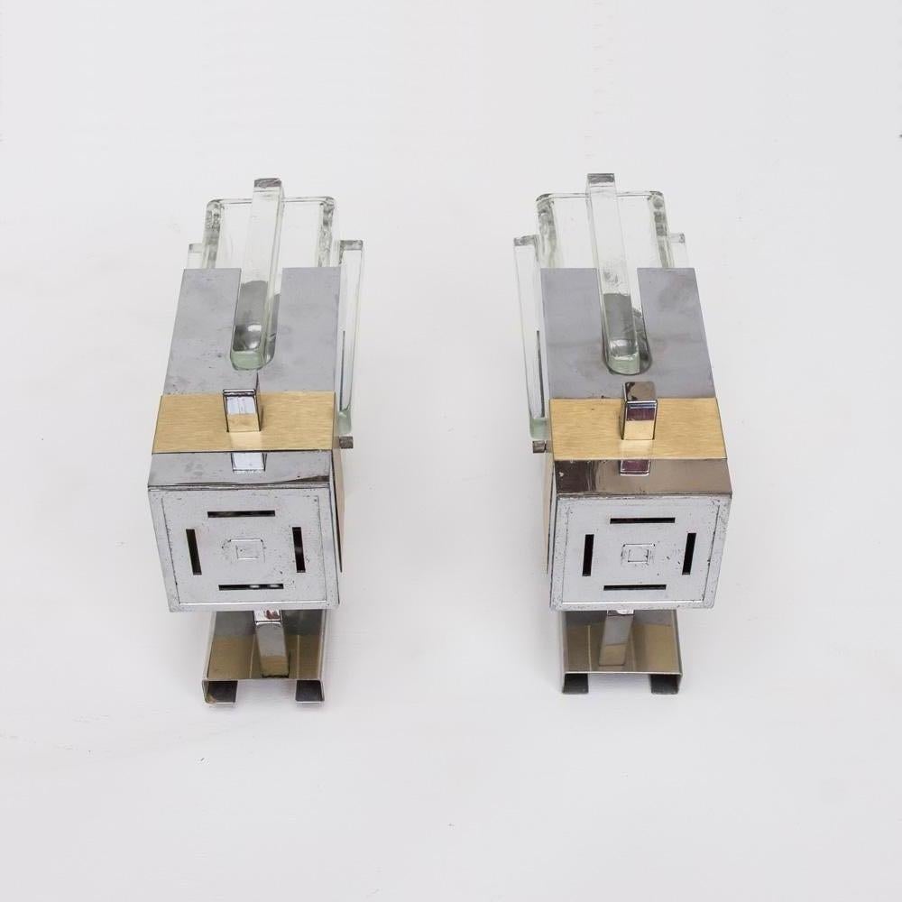 1970s great pair of wall lights. Modernist style Italian design by Gaetano Sciolari. Thick Clear glass shades on a brushed steel structure with brass decoration.
This pair of sconces are a good example of Sciolari's work of the mid-1960s to the