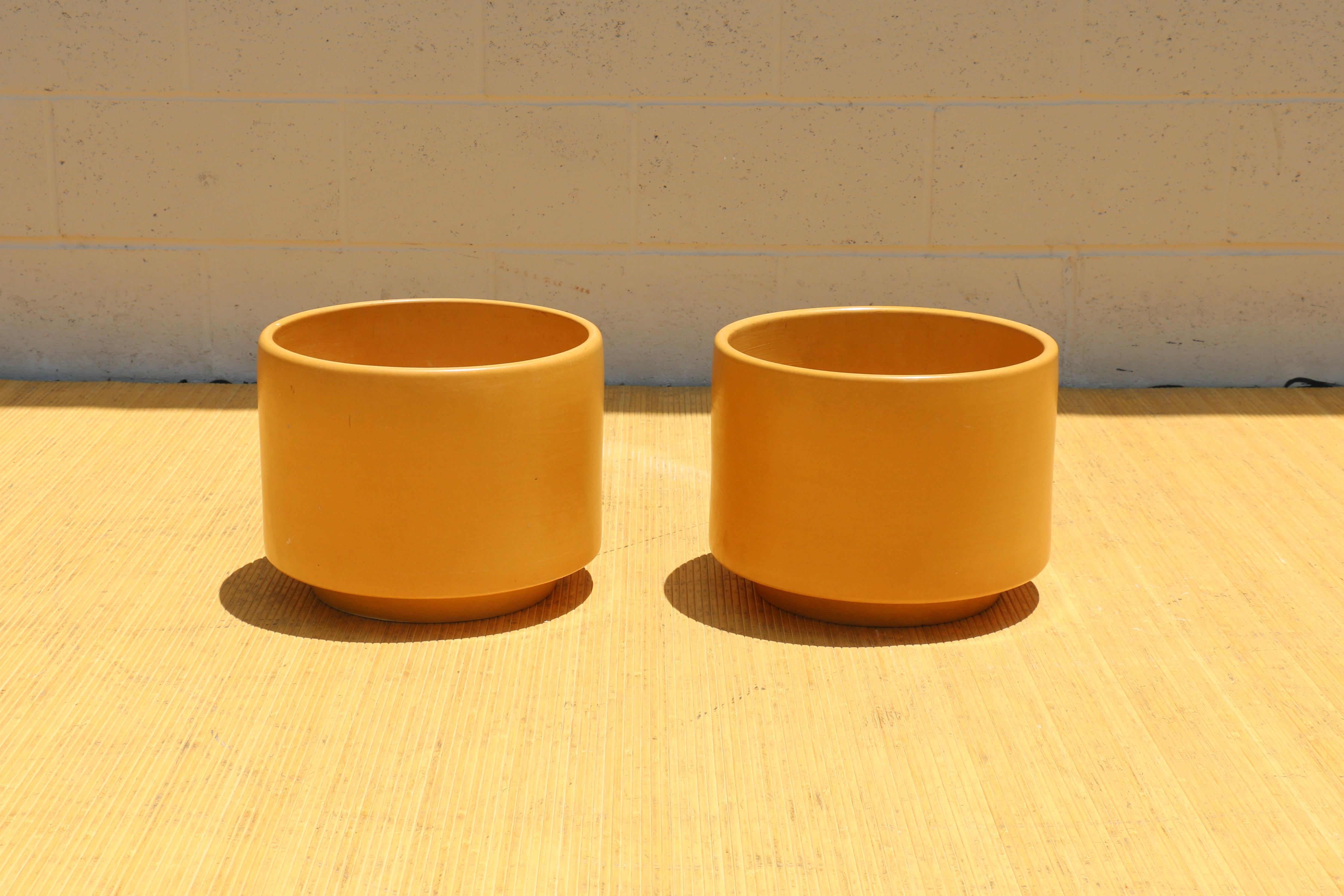 Spectaculaire paire de jardinières à la glaçure jaune satinée. Un seul porte la marque du fabricant dans le fond. Ils sont fabriqués en Californie. Ils sont d'origine et datent des années 1970. Elles sont en bon état. Sans aucun problème. Ils sont