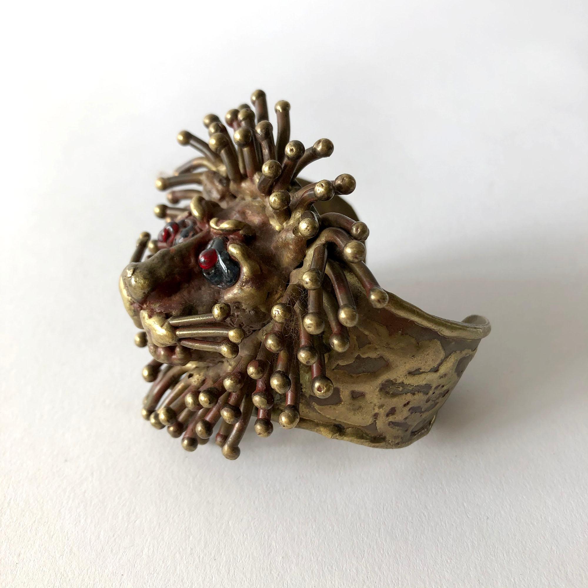 1970's handmade bronze lion bracelet with spiky mane and glass eyes created by Pal Kepenyes of Acapulco, Mexico.  The sculptural Iion element measures 3