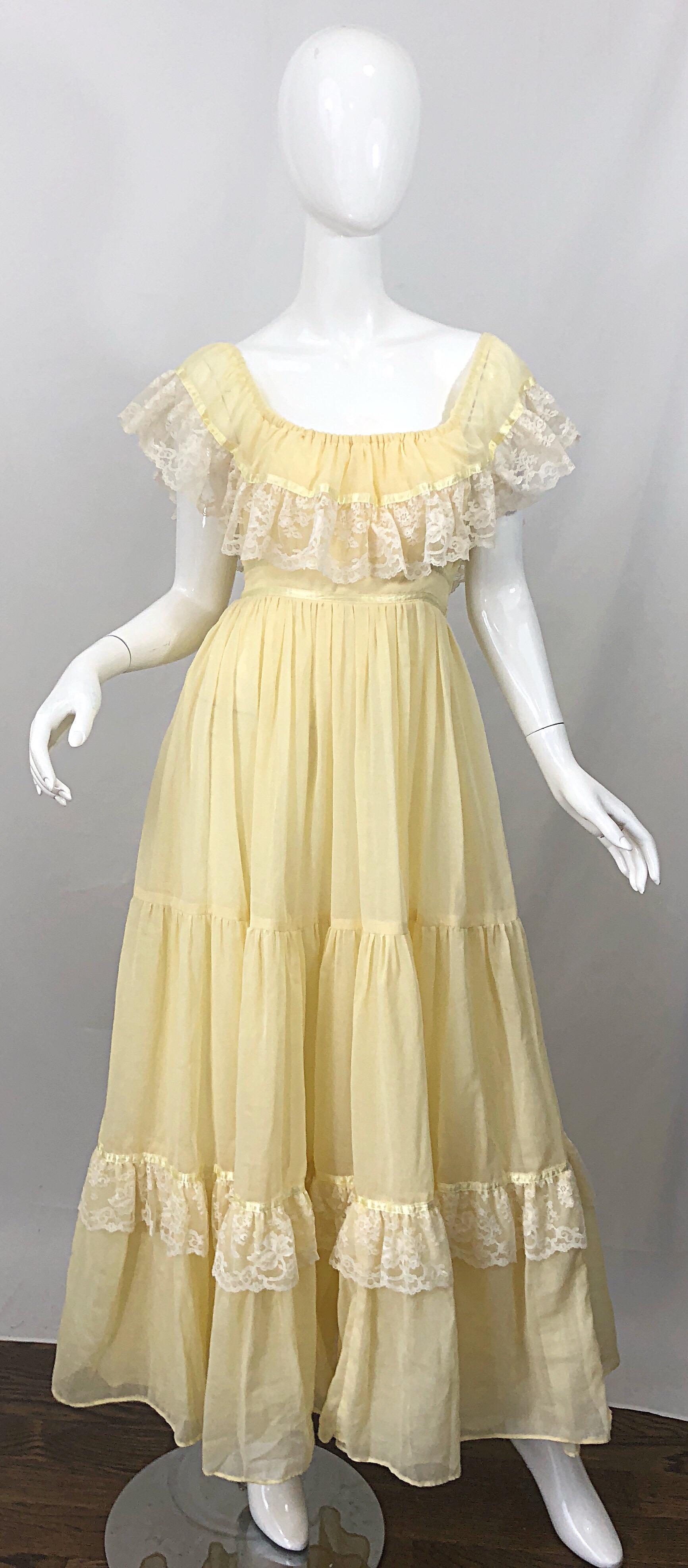 Amazing 1970s pale yellow and white cotton voile and lace boho empire maxi dress! Features white lace around the bodice and at the ruffle hem. Can be worn on or off the shoulders. Flattering empire waist is easy to wear. Ties at back waist can