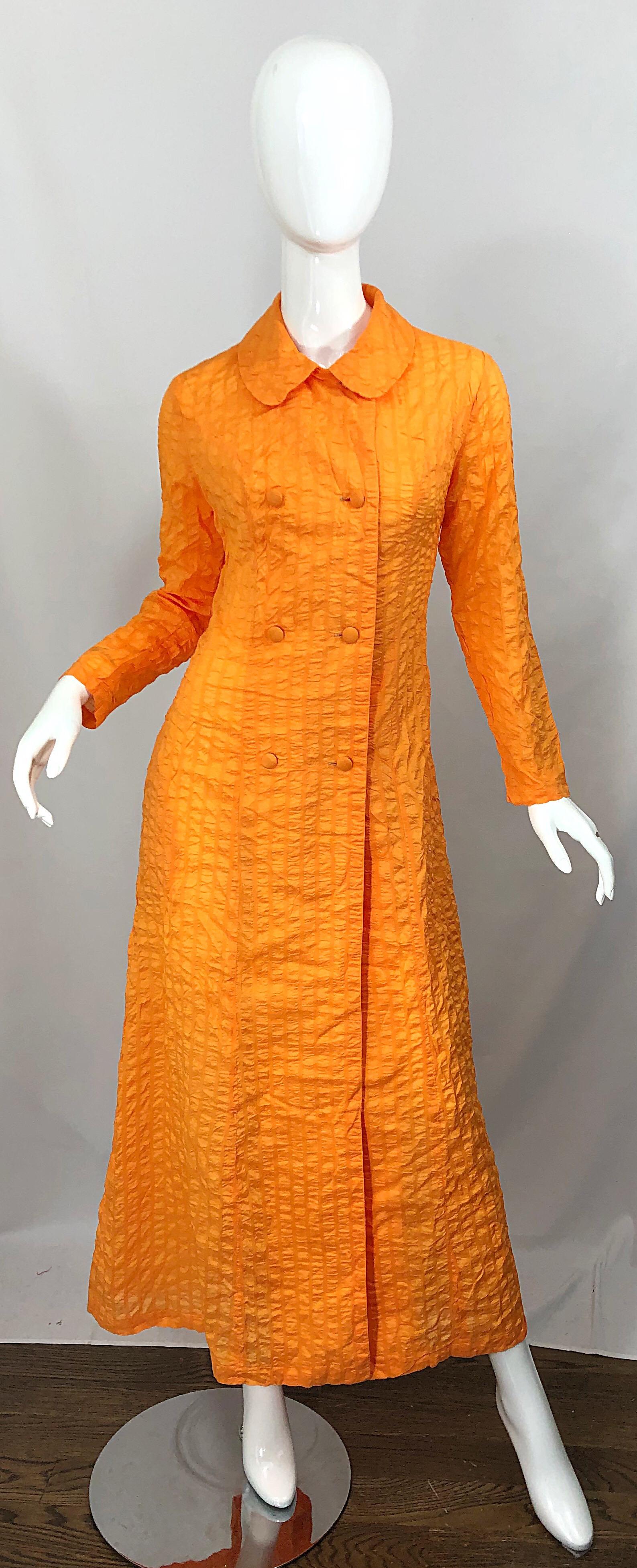 Aggiungi un tocco di colore a qualsiasi outfit con questo raro cappotto vintage della metà degli anni '70 PALMERS a doppio petto di colore arancione brillante! Presenta un morbido tessuto increspato in misto seta e nylon. Bottoni rivestiti in
