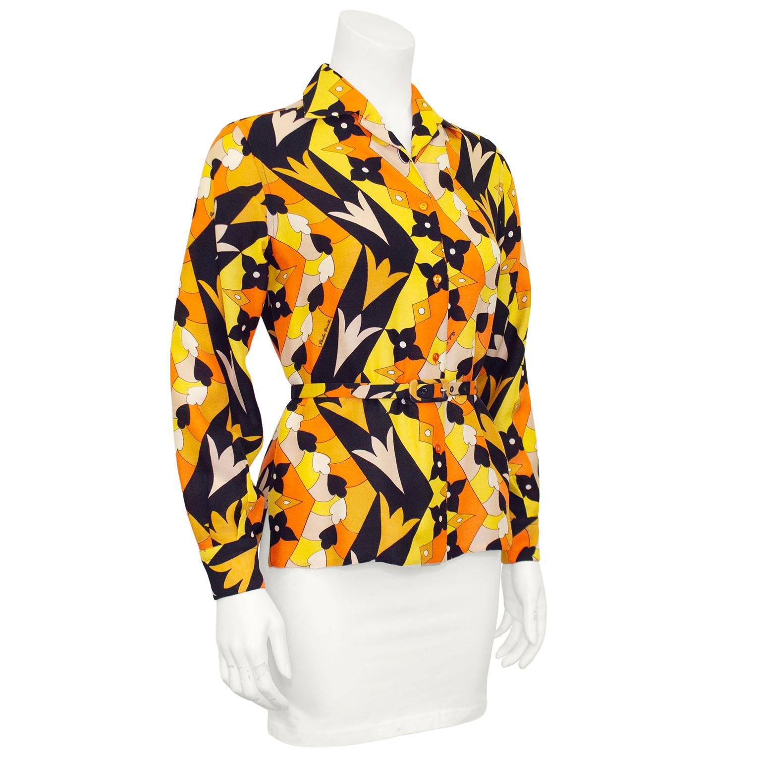 1970s Pucci-esque printed blouse by Paola Davitti Firenze. Orange, yellow, black and cream all over geometric signed print. High, shallow collar, small orange buttons and small slits at both side seams. Optional matching thin belt at waist that adds