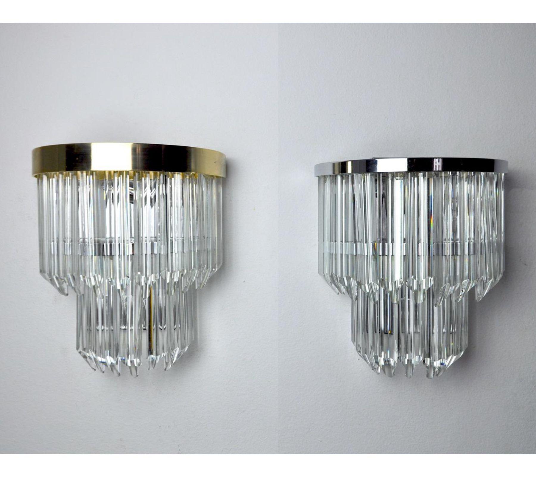 Very beautiful duo of appliques produced in Italy in the 70s. Cut glass and two separate structures, one in gilded metal and chrome-plated. Unique design object that will illuminate perfectly and bring a real design touch to your interior.