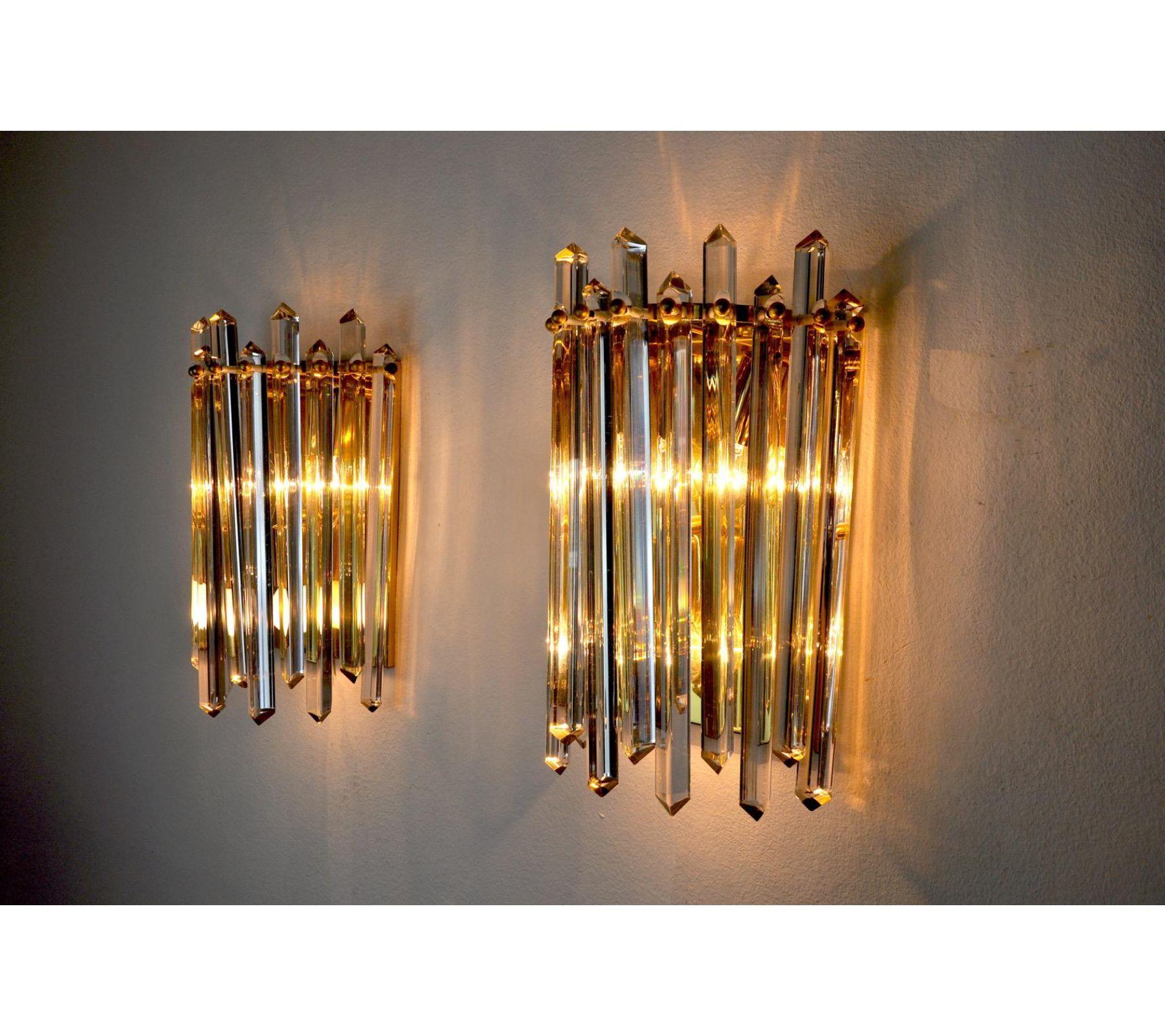 Very nice pair of wall lamps produced in Italy in the 70s. Cut glass and gilded metal structure. Unique design object that will illuminate perfectly and bring a real design touch to your interior. Electricity verified, time mark relative to the age