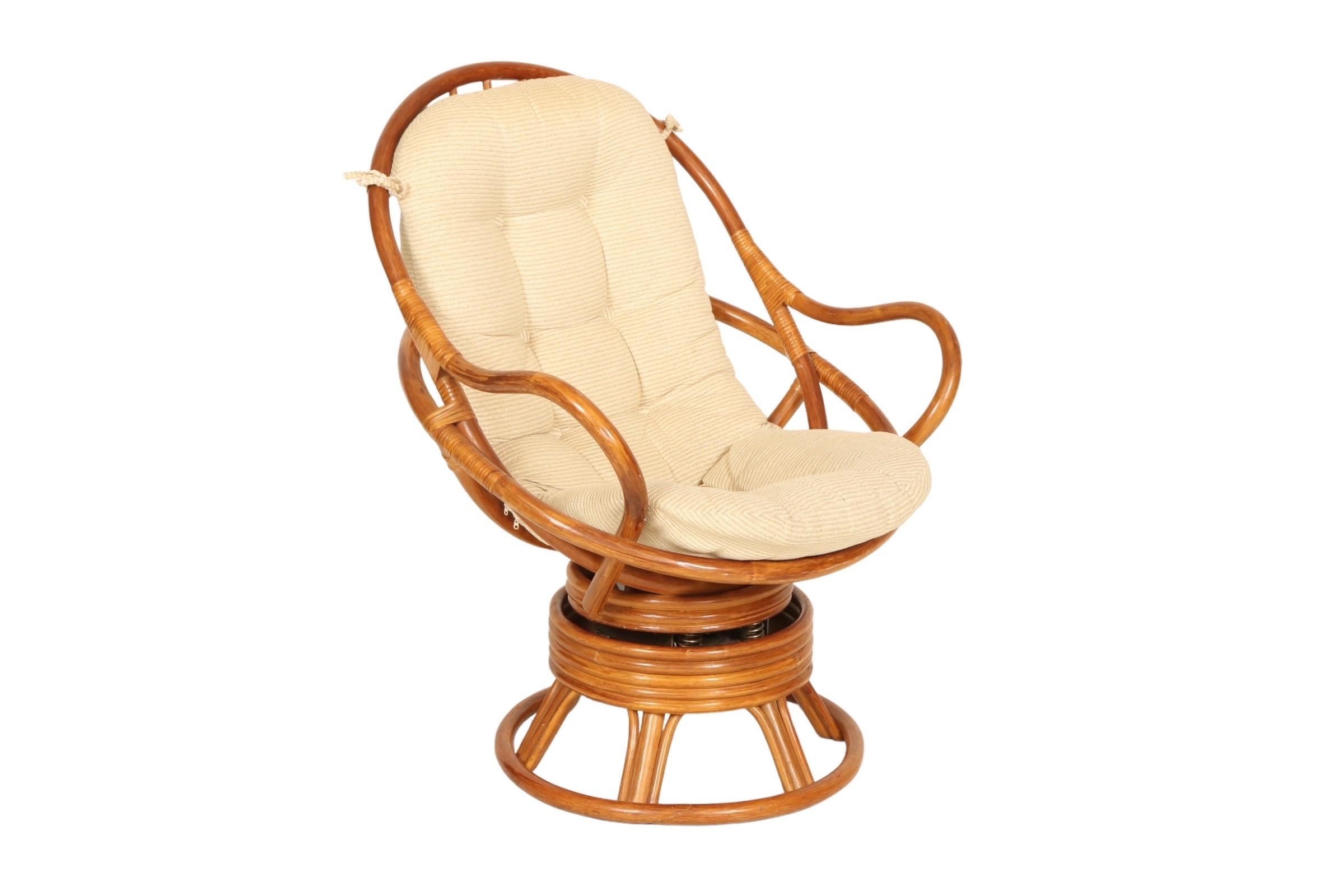 A Mid-Century Modern Papasan style bamboo lounge chair that swivels and rocks, made by Grand Basket Company Inc. Bentwood bamboo curves to form a gentle egg shape with round armrests, secured at the joins with rattan. The round pedestal base is made