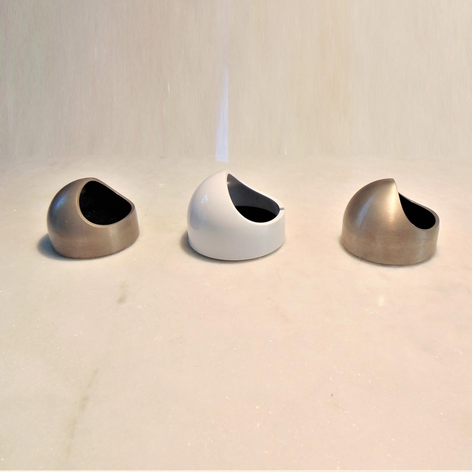 Marco Melocchi and Franco Bettonica designed the Nautico ashtray paperweight vide-poche deskset in 1975. This design is still part of the MOMA collection. Two of these objects are in brushed steel, with a black acrylic floor and bottom. The white