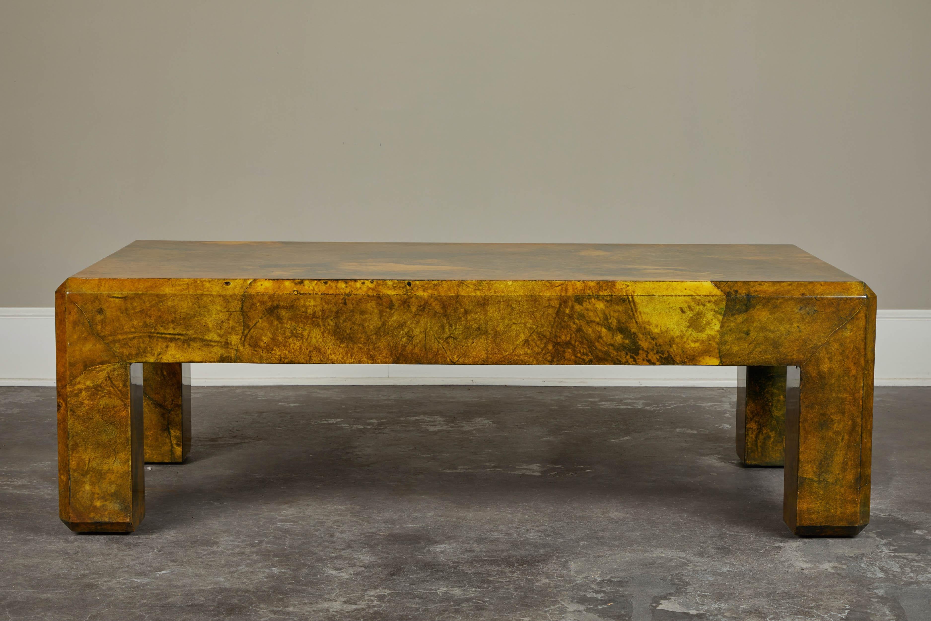 A 1970s Karl Springer parchment coffee table. Rectangular shape, beveled edges and great squat proportions. Medium sheen and overall warm gold and green tones.