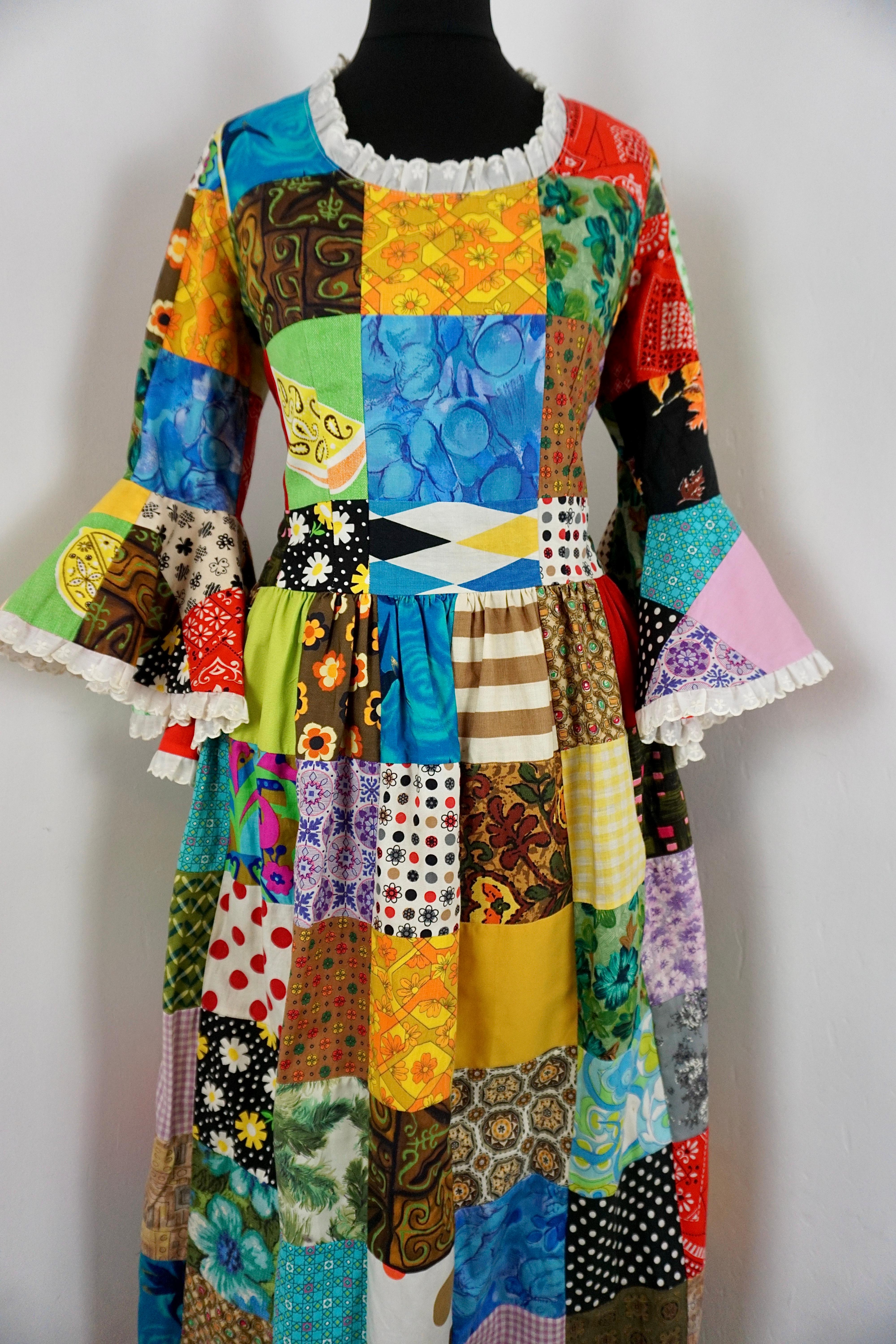 Incredible 1970s handmade patchwork dress. This stunningly unique piece has a fitted bust with a floor length gathered skirt, her sleeves are long and slim fitted  flaring out with full circle cuffs lined in a bright red for a pop of block