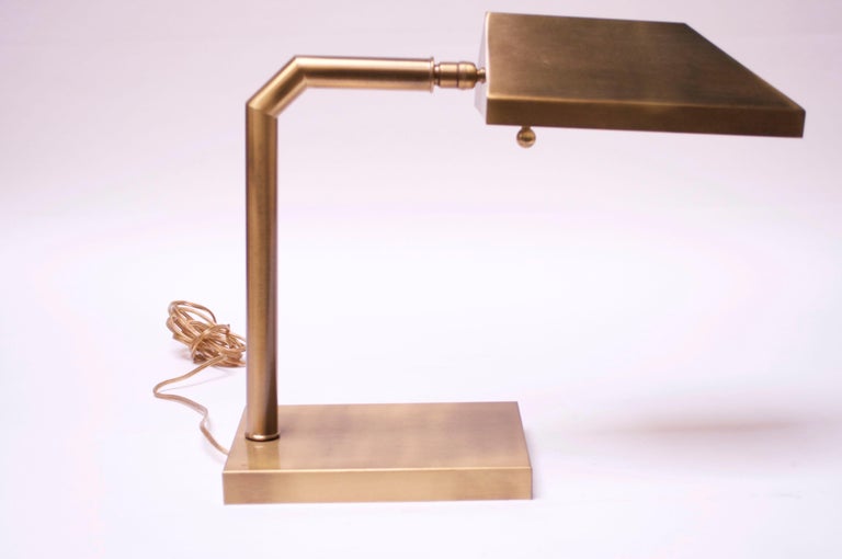 1970s Chapman table lamp, combining industrial and modern design. Composed entirely of brass, this lamp also feature the signature bronze finish and dimmer 'ball' knob with a uniquely thick or wide shade. The shade is fully adjustable, offering full