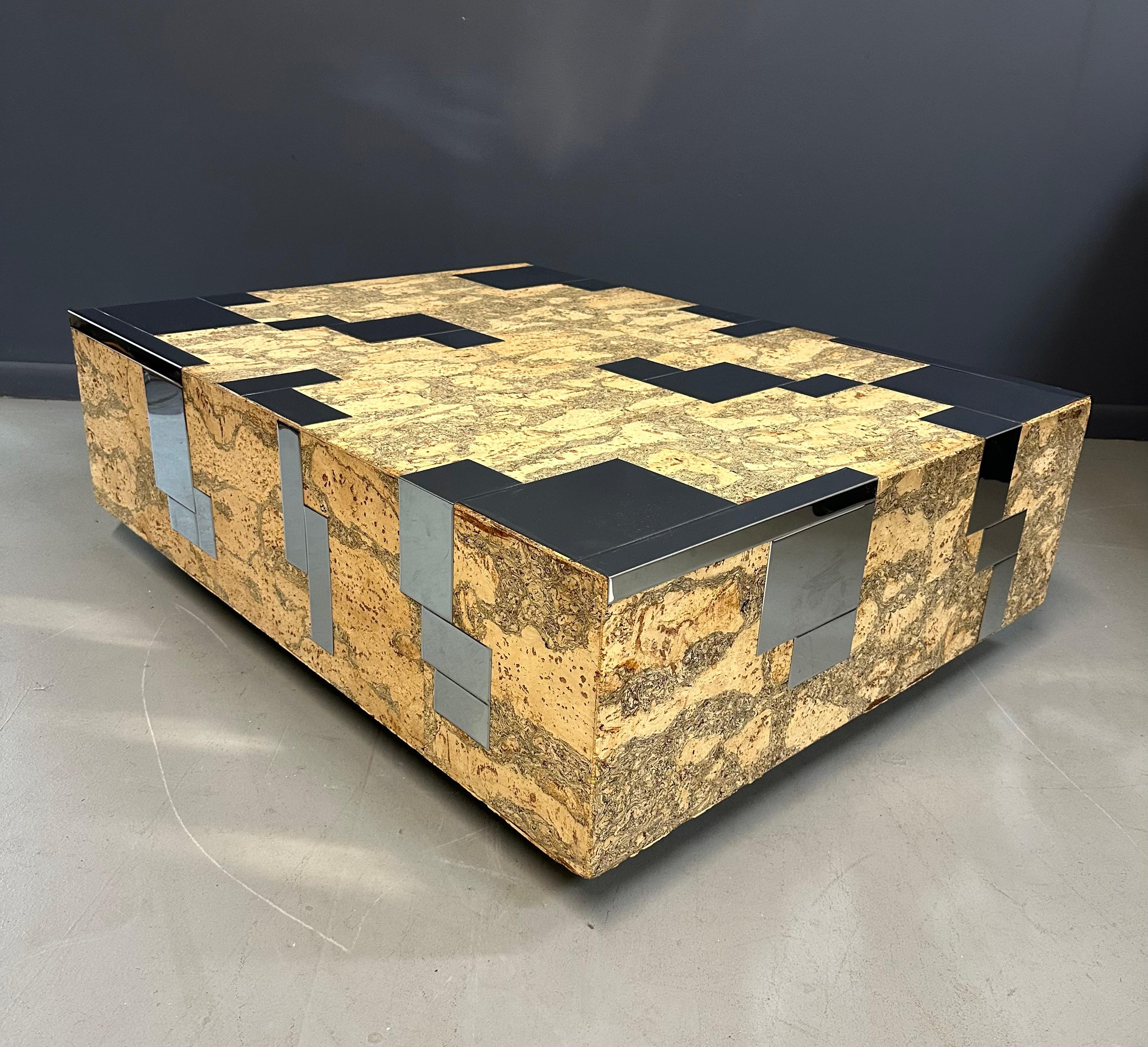 Conçue dans le style du designer des années 1970 Paul Evans, cette table basse présente un joli design en liège et en acier inoxydable au grain complexe, reposant sur un socle noir. Avec son look vintage intemporel, il ajoute une touche de
