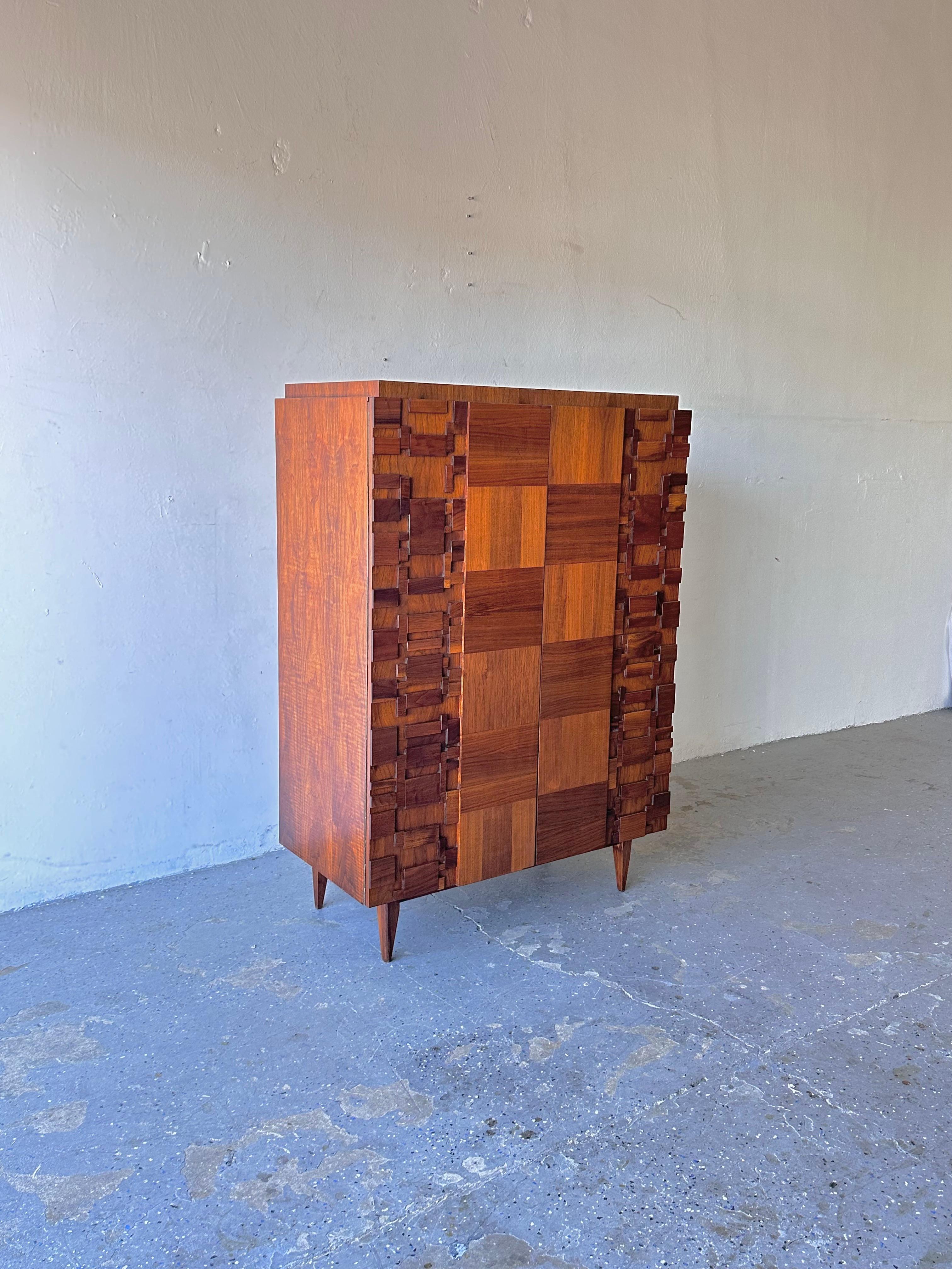 1970s Paul Evans Style Lane Brutalist Mid Century  Armoire

Mid-Century Modern Brutalist Wardrobe, Armoire, Dresser. An incredible brutalist wardrobe/highboy  in walnut wood. The center front has  panels in alternating grain, creating a patchwork
