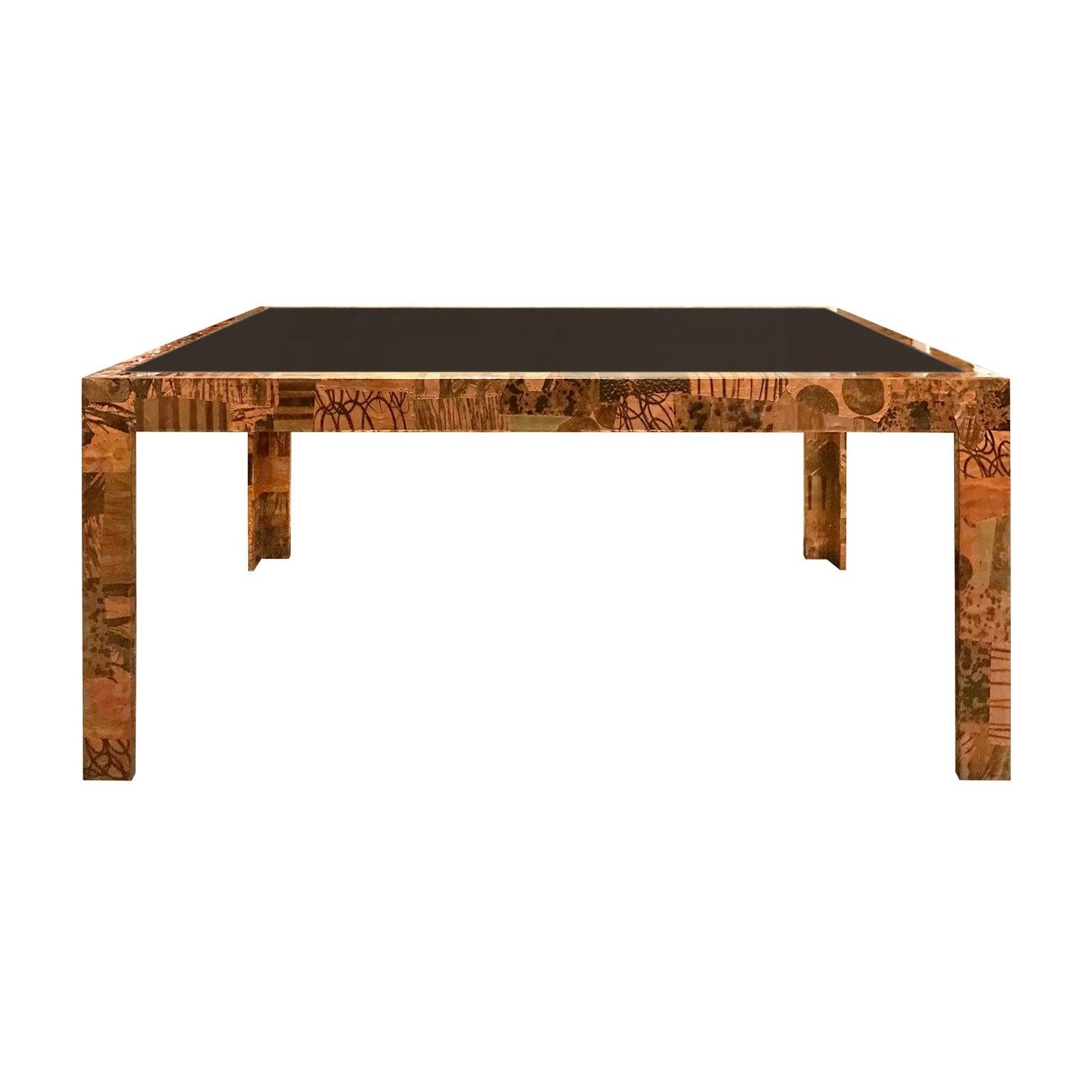 Paul Evans style patchwork metal dining table in copper, brass and pewter with smoked glass top, USA, 1970s.
 