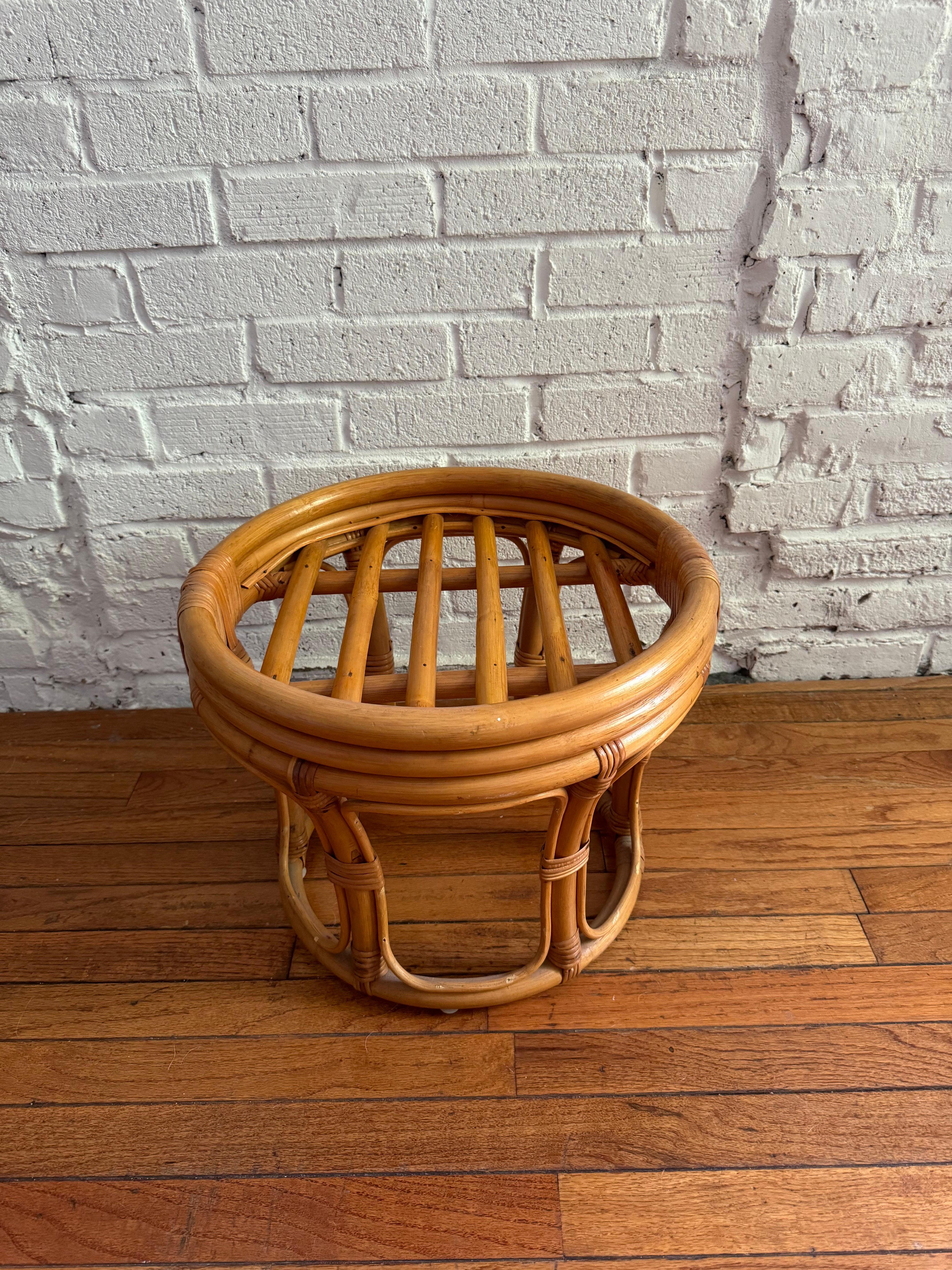 Vintage 1970s round rattan foot stool, similar in style to Heywood Wakefield and Paul Frankl pieces. This piece can be used with the included floral cushion with self-went detail for a comfortable ottoman/foot rest, without as a stand for plants or
