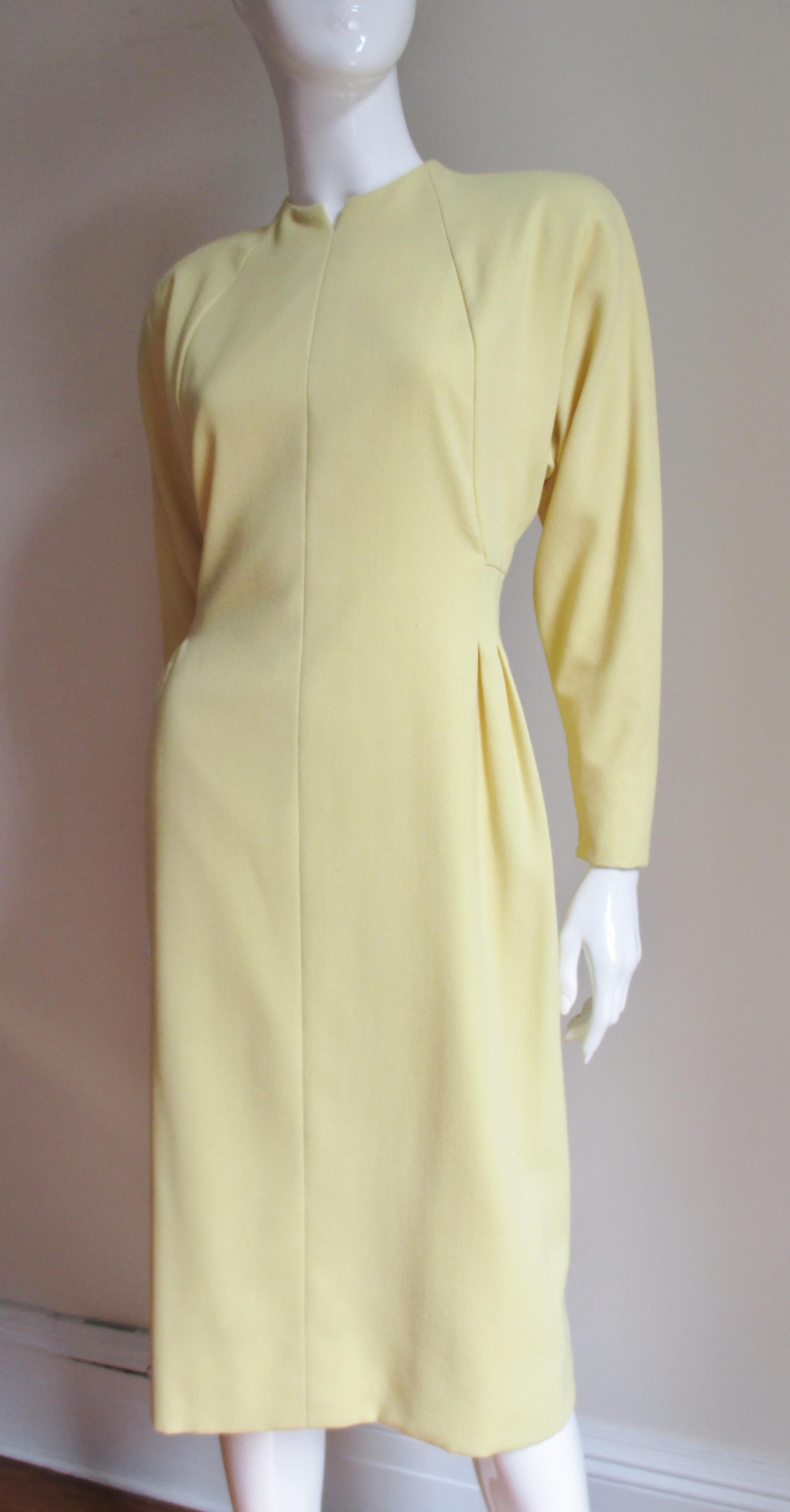 A pretty lemon yellow light weight wool dress from Pauline Trigere.  It has a notched crew neckline, light shoulder padding and dolman sleeves with zipper cuffs.  There is angled seaming on the bodice front and back creating flattering lines and the