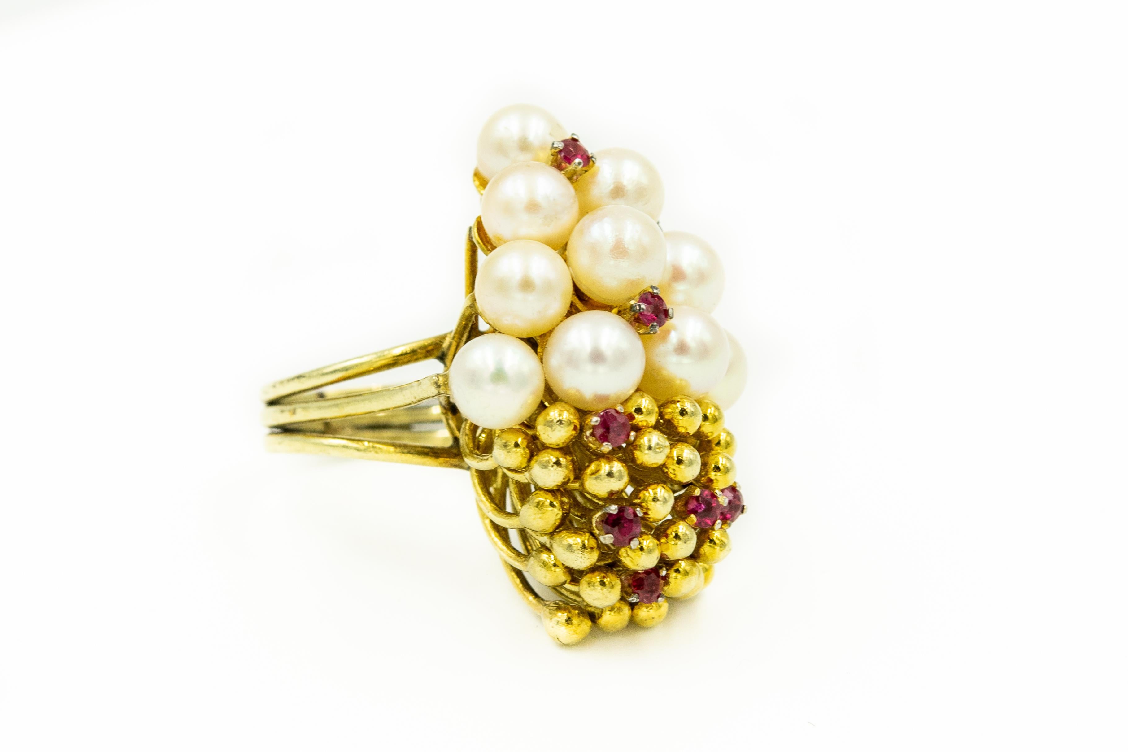 Splendido anello tridimensionale in oro giallo 14k con un grappolo di dieci perle coltivate su un lato e piccole perle d'oro sull'altro lato.  Entrambe le aree sono impreziosite da rubini incastonati.  A seconda della direzione in cui lo indossi,