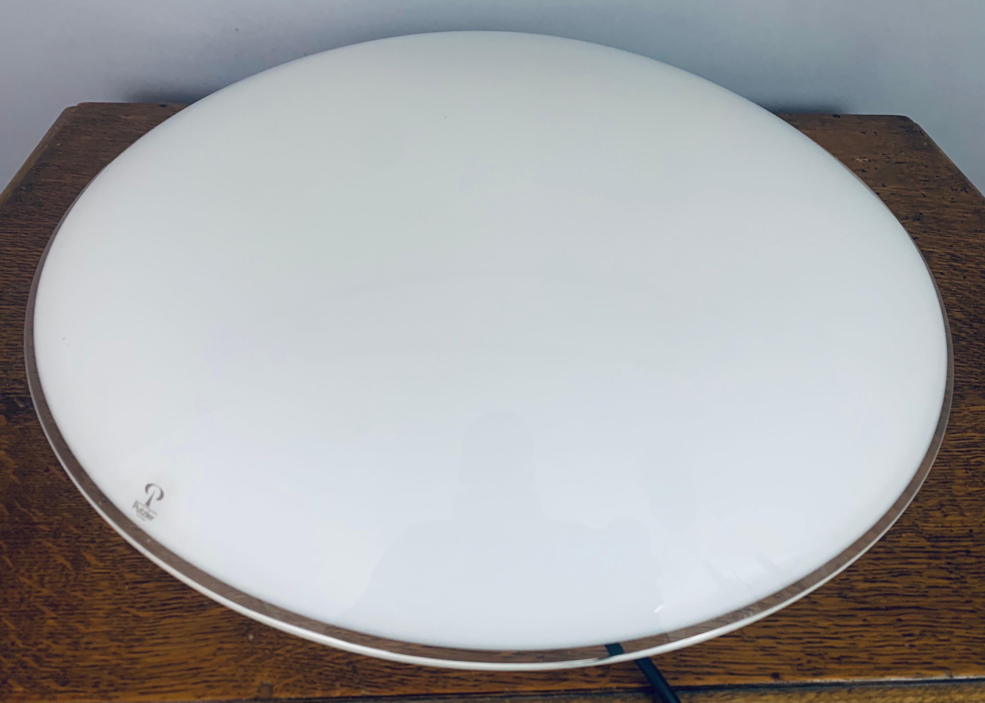 1970s German Peill & Putzler opaline 'flying saucer' wall light or ceiling flush mount.  The white opaline glass is encased with clear glass which is particularly visible around the outside edge.  Three screws hold the glass shade onto the white