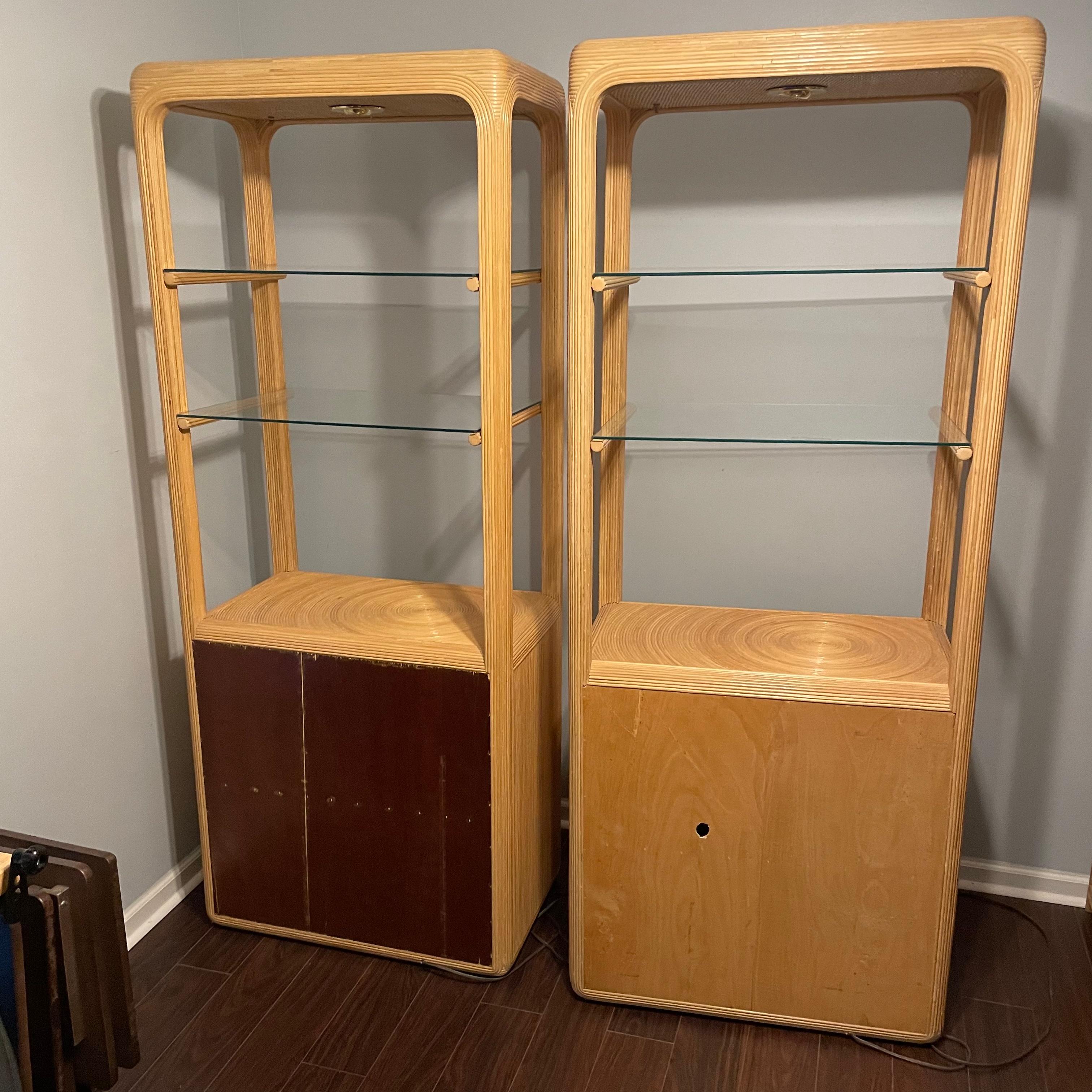 Pair of vintage 1970s etageres / cabinets with a spotlight in the top and two glass shelves below the light. Behind the double doors are two shelves. These are both in good condition for their age. The two glass shelves are removable for easy and