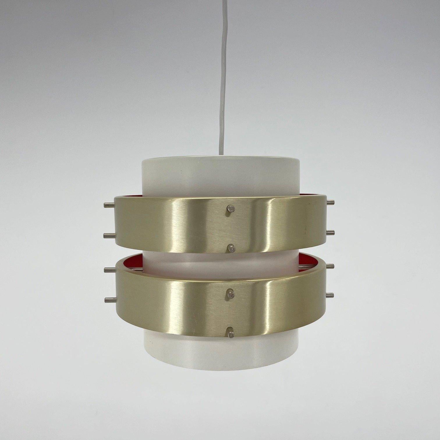 Modernist metal pendant probably from the 1960's. Made in the former GDR (East Germany). The shade is made of two interconnected metal hoops, which are painted red on the inside and reflect the colour when the light is on. The pendant is reminiscent