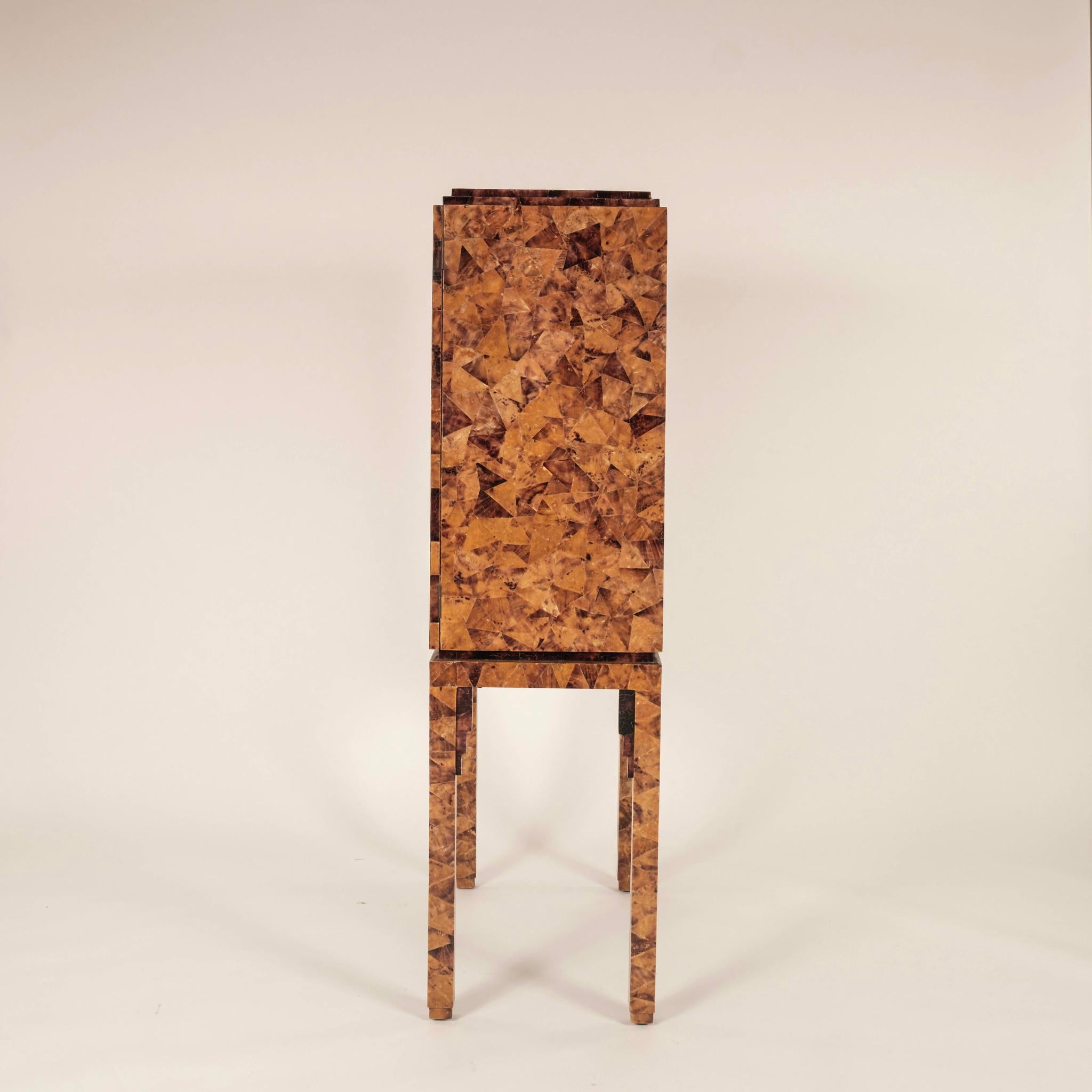 1970s Penshell dry bar cabinet featuring a penshell veneer that carries completely around to the back with beautifully carved carved bone ivory face knobs.
