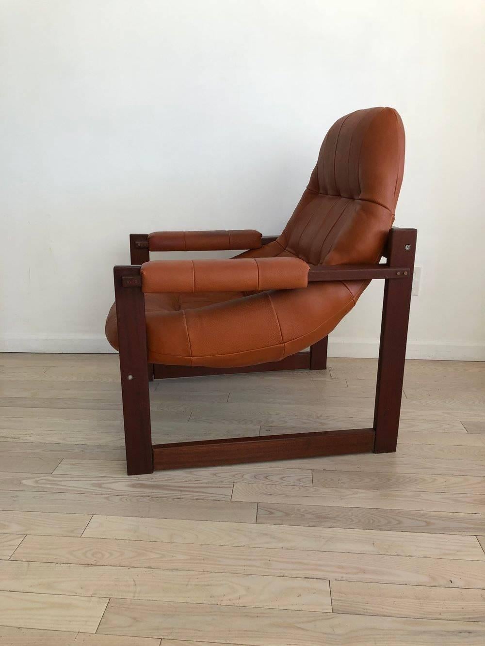 Super rare 1970s leather and Brazilian rosewood lounge armchair. Tufted leather egg shaped floating seat. Super cozy and comfortable. Made in Brazil, circa 1970. Light staining on arm rest and headrest from use. Super sturdy and awesome