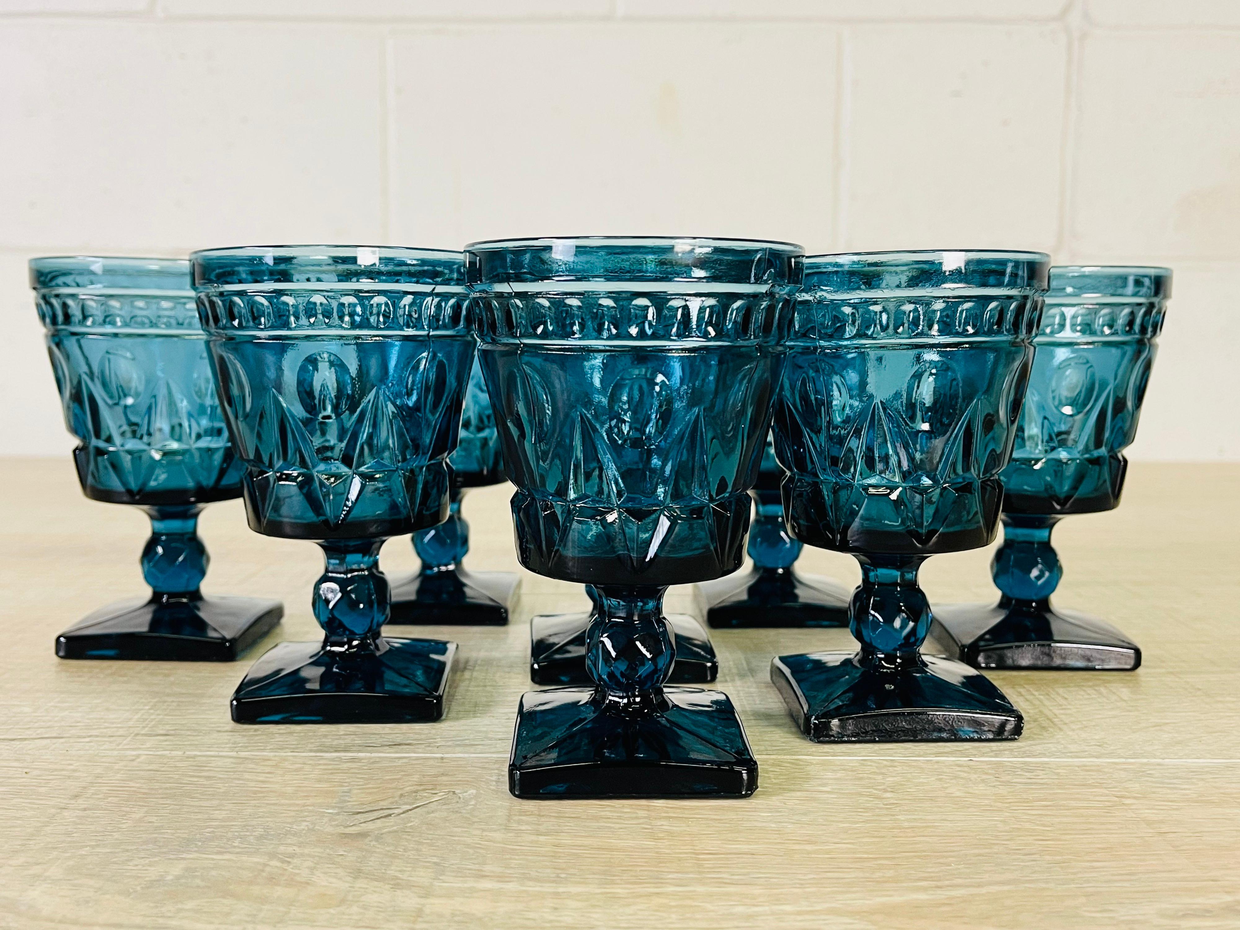 Vintage 1970s set of eight periwinkle blue glass footed goblets. No marks.