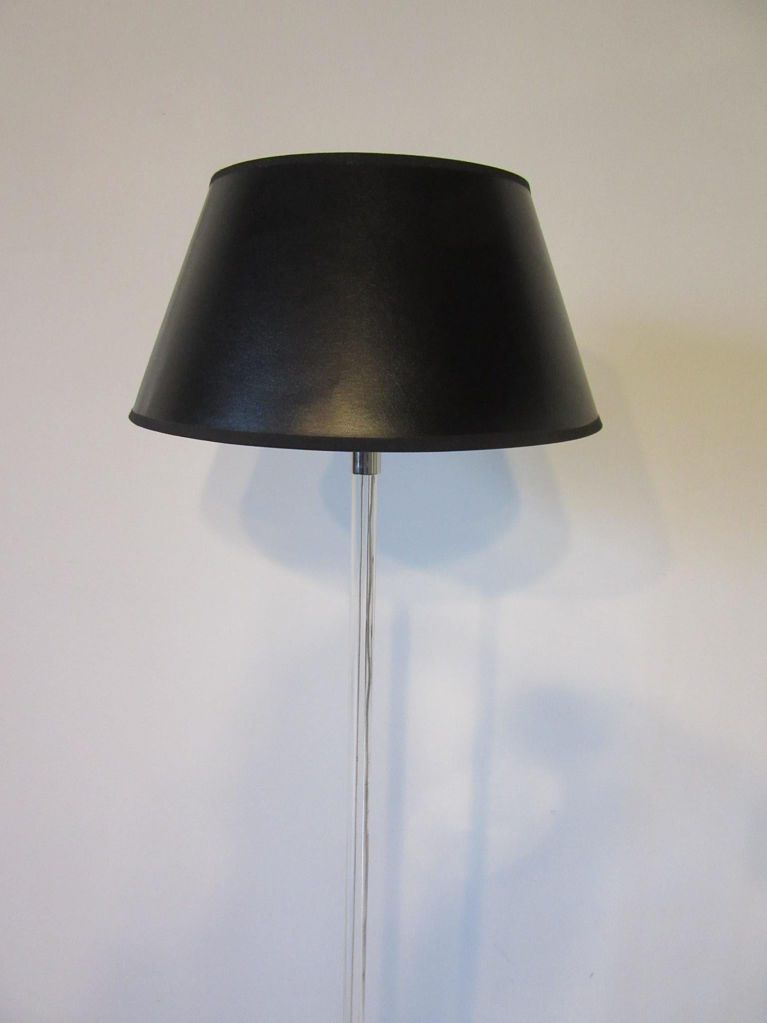 A simple elegant Lucite and chromed floor lamp with circular base designed by Peter Hamburger and distributed by Knoll.