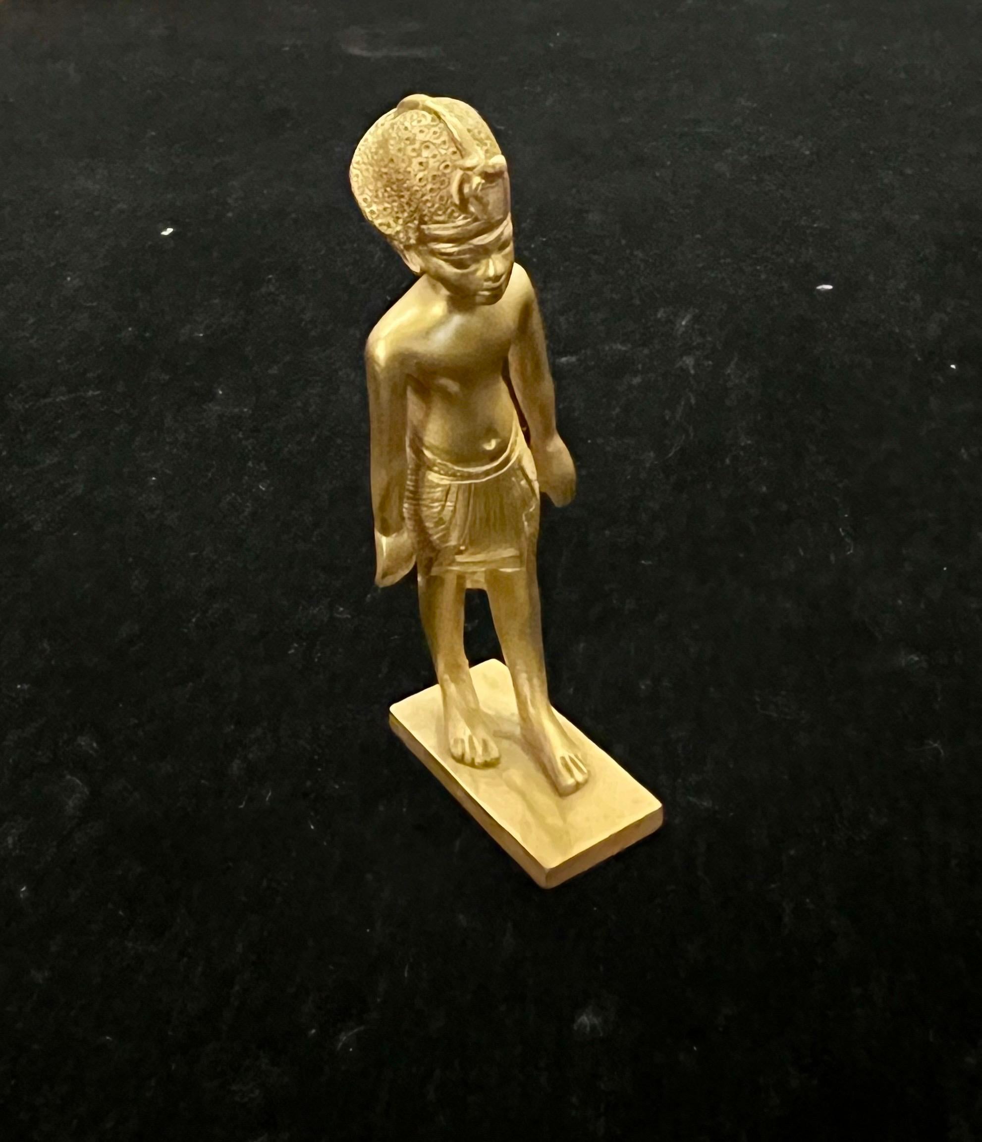 Raro 1970's Acabado en oro sobre latón pequeño El niño rey estatua. por El museo Metropolitano de arte .Rey Tut.