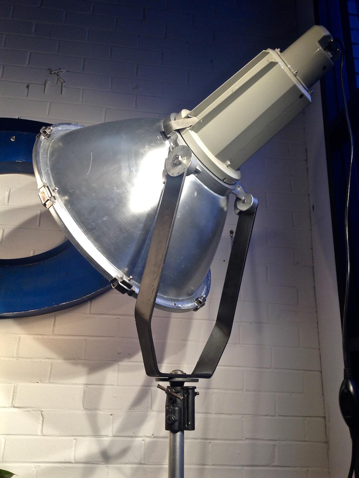 This is an original Phillips industrial studio light with an alloy Manofrotton tripod base/stand.
This has been cleaned, polished and re-wired to take a standard household bulb and is in good working order. In very good vintage condition and fully
