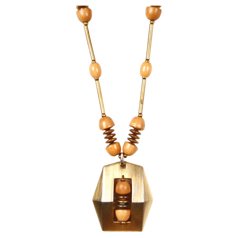 Long gilt necklace with spinning wood beads designed by Pierre Cardin dating to the 1970's. Light in weight. Good condition. 