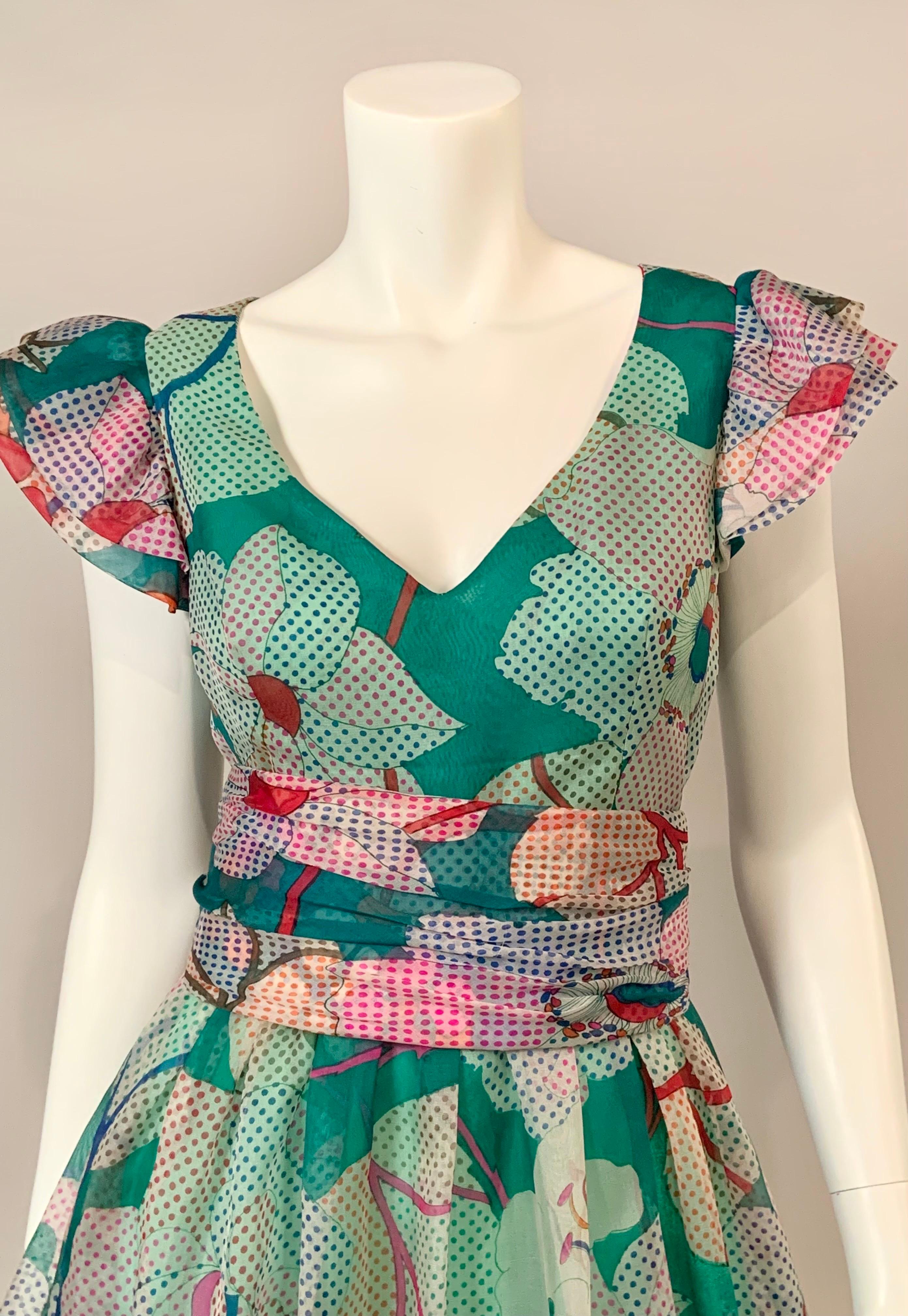 Dieses Kleid von Pierre Cardin scheint mir das perfekte Sommerkleid zu sein.  Der Op-Art-Druck besteht aus Flächen mit Punkten in vielen Farben und Blumen in denselben Farben auf weißem Hintergrund.  Das Kleid hat einen V-Ausschnitt, gerüschte