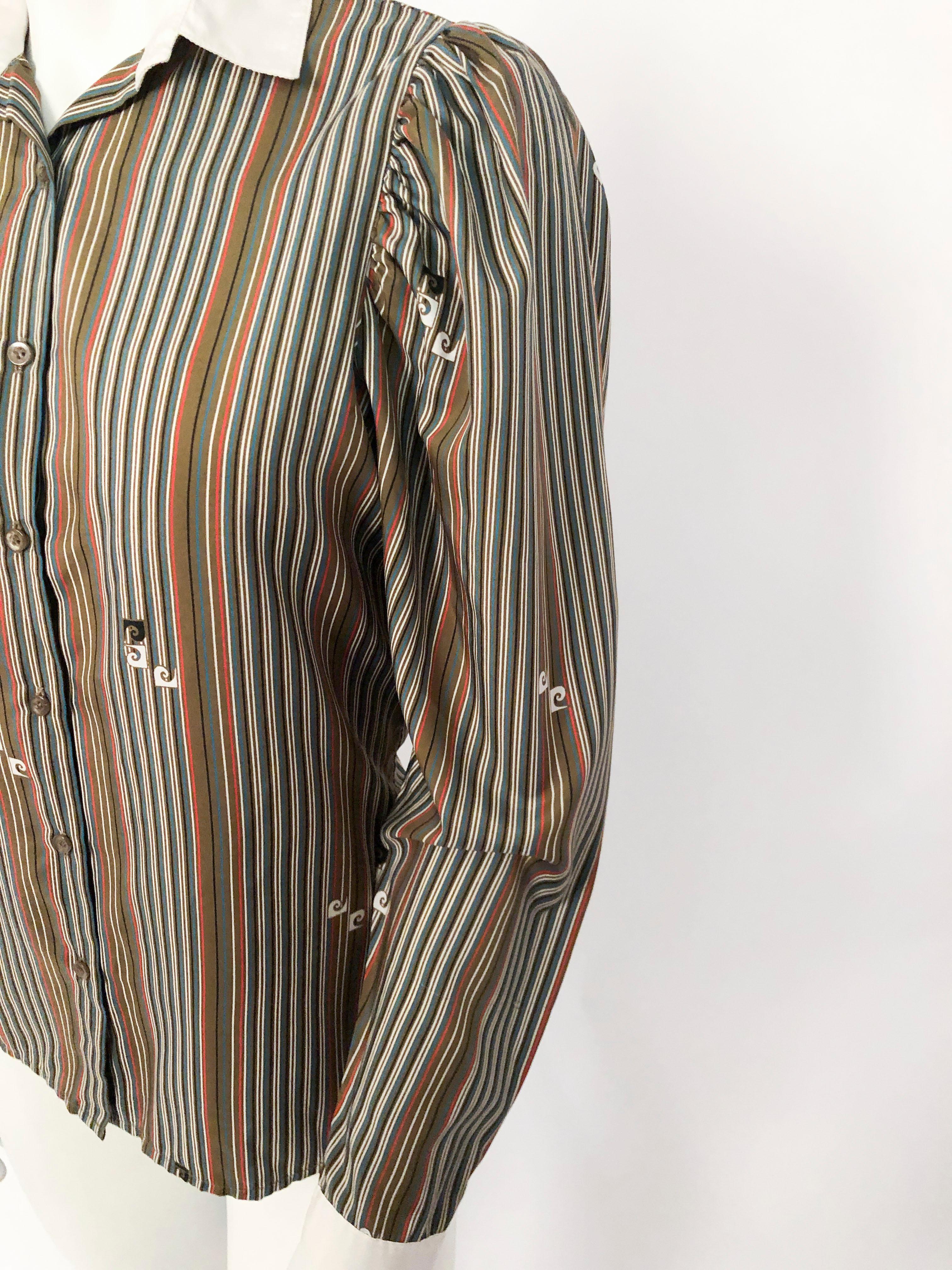 1970s Pierre Cardin Striped Blouse featuring multi-colored motif and dispersed Pierre Cardin logo. White collar and cuffs with slight puff shoulders