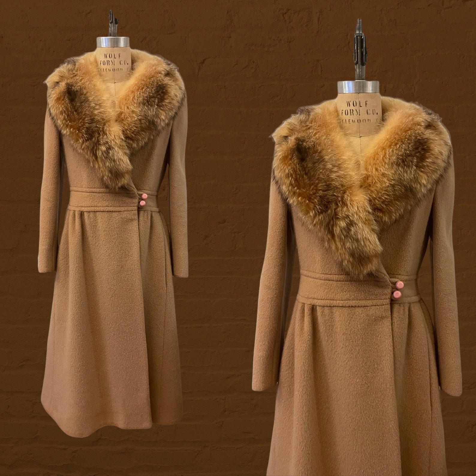 Pierre Cardin camel beige wool princess coat
fit and flare silhouette
notch lapel fox fur collar
princess seams
banded waist
blush pink buttons at waist & sleeve cuffs
two button closure at left side gives this coat a wrap style look
hip