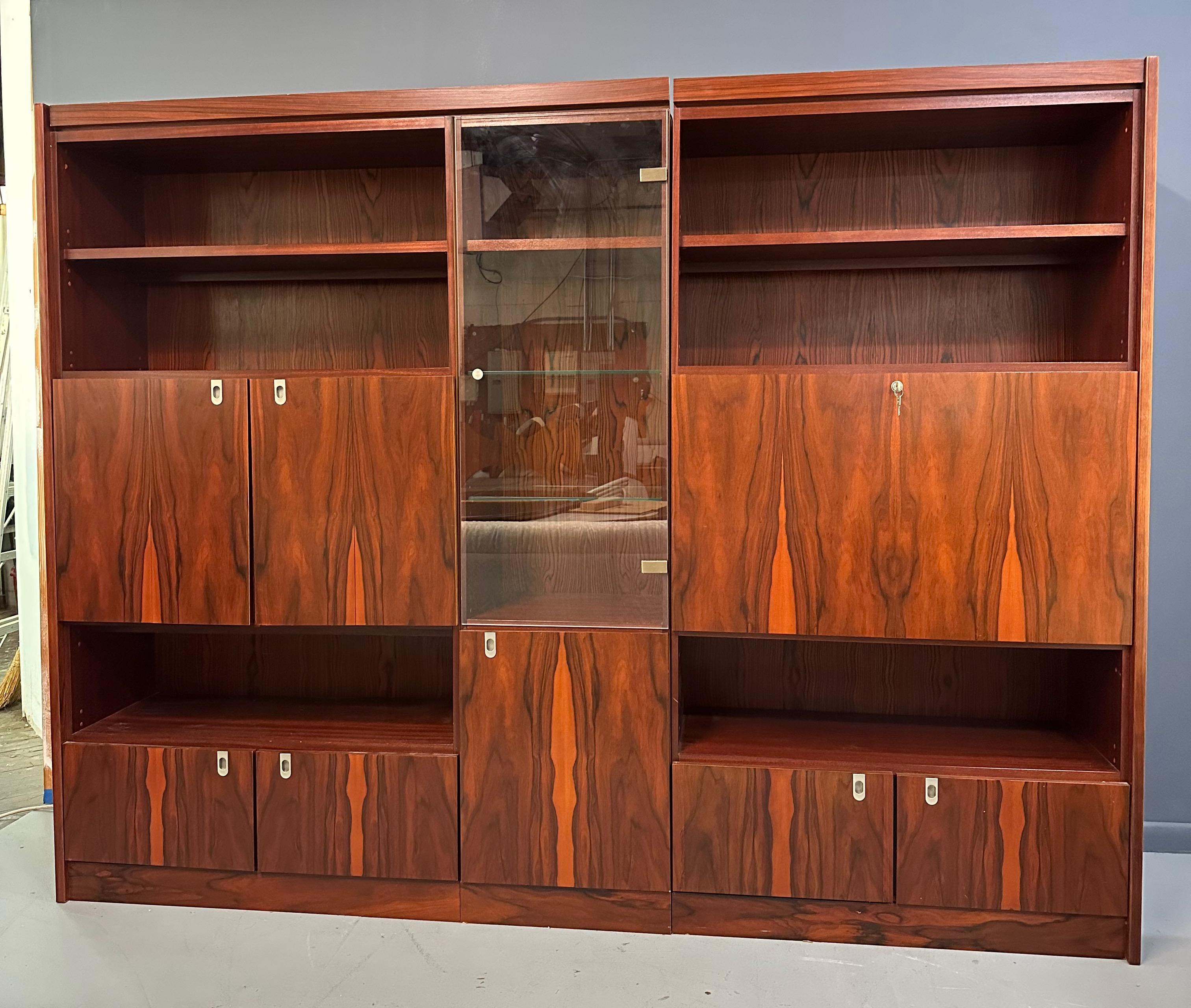 This 1970s Planum Rosewood and Mahogany Lighted Wall Unit with Desk Mid Century is an exquisite blend of style and functionality. The lighted wall unit provides ample storage and display space, and the unique desk design makes for a beautiful