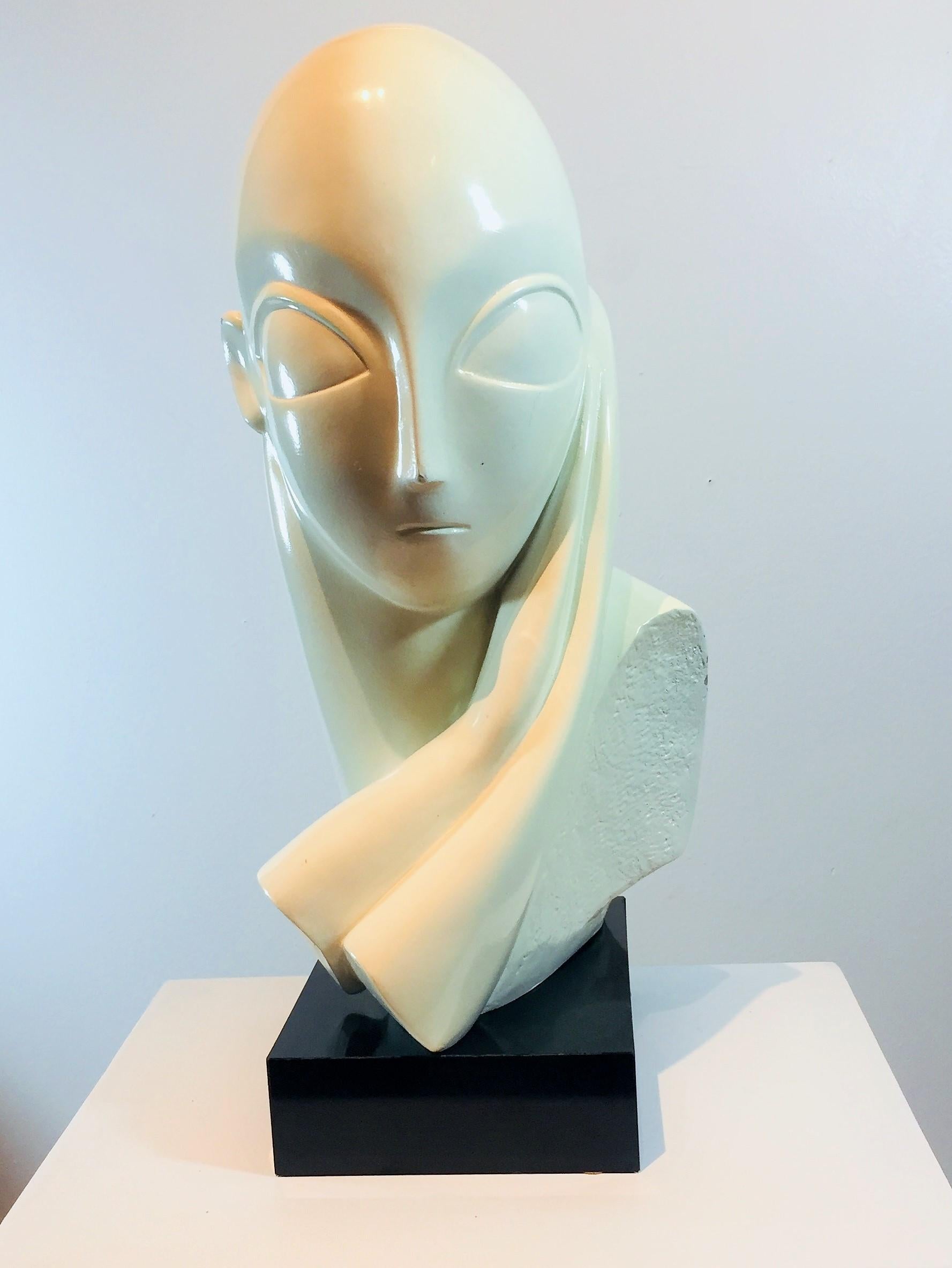 Plaster female sculpture by Austin Productions, Inc. Off-white in color. Left shoulder and right ear have visible chips (the most noticeable is at left shoulder, as in image 5). 

Mounted on a black composite wood base, with a total measurement of