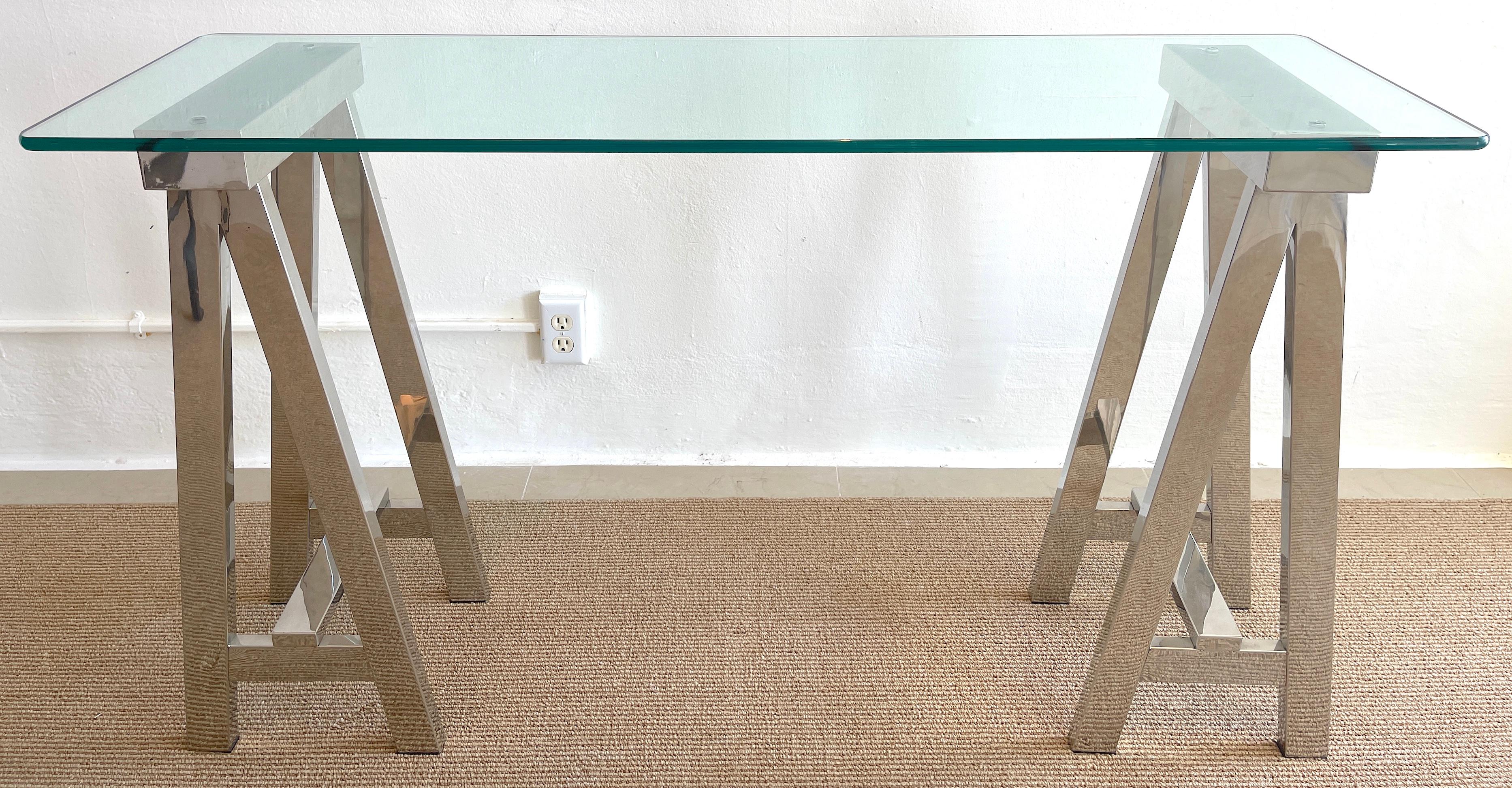 1970s polished chrome sawhorse console table, A fine vintage example of an iconic form, the thick (.75) rounded edge glass top resting on two 12