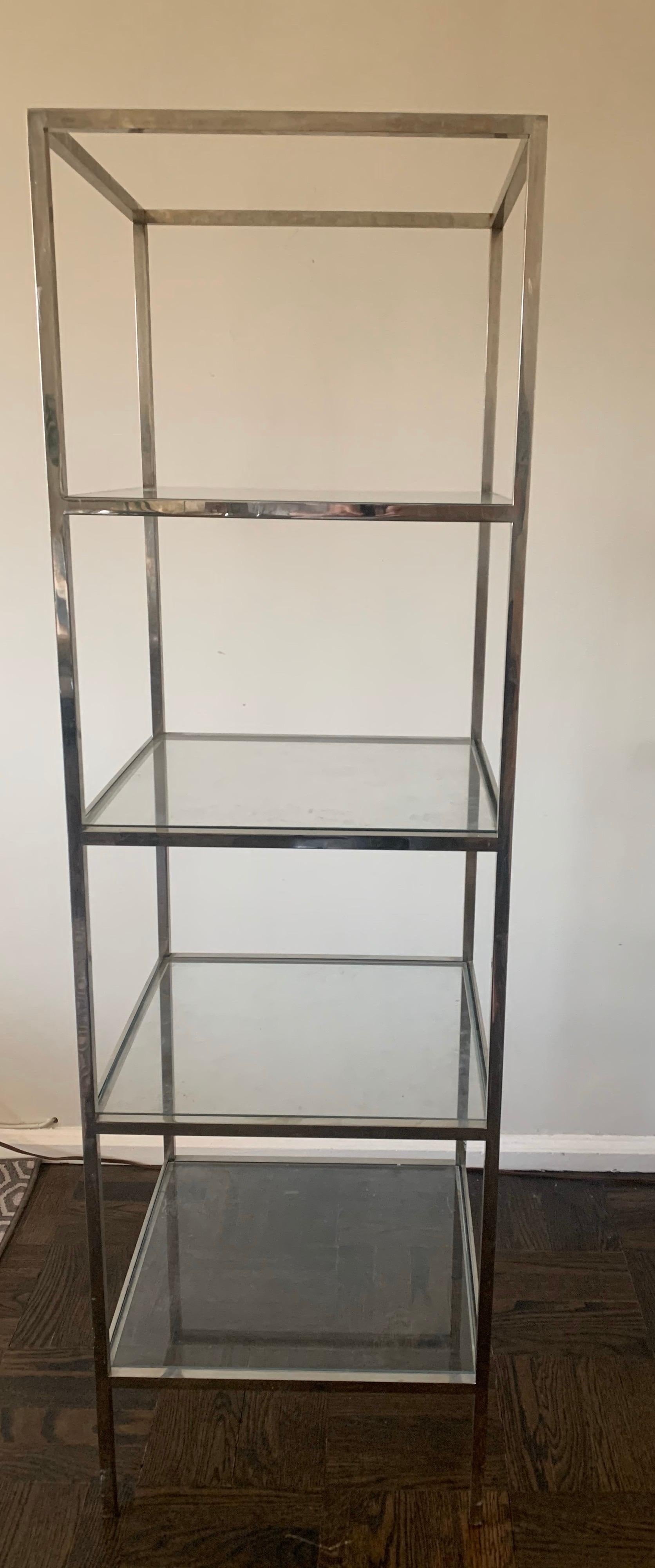 1970s polished chrome étagère or bookcase with 4 square glass shelves. Very heavy solid chrome construction with thick clear glass shelves. Each shelf is 12.5” tall.