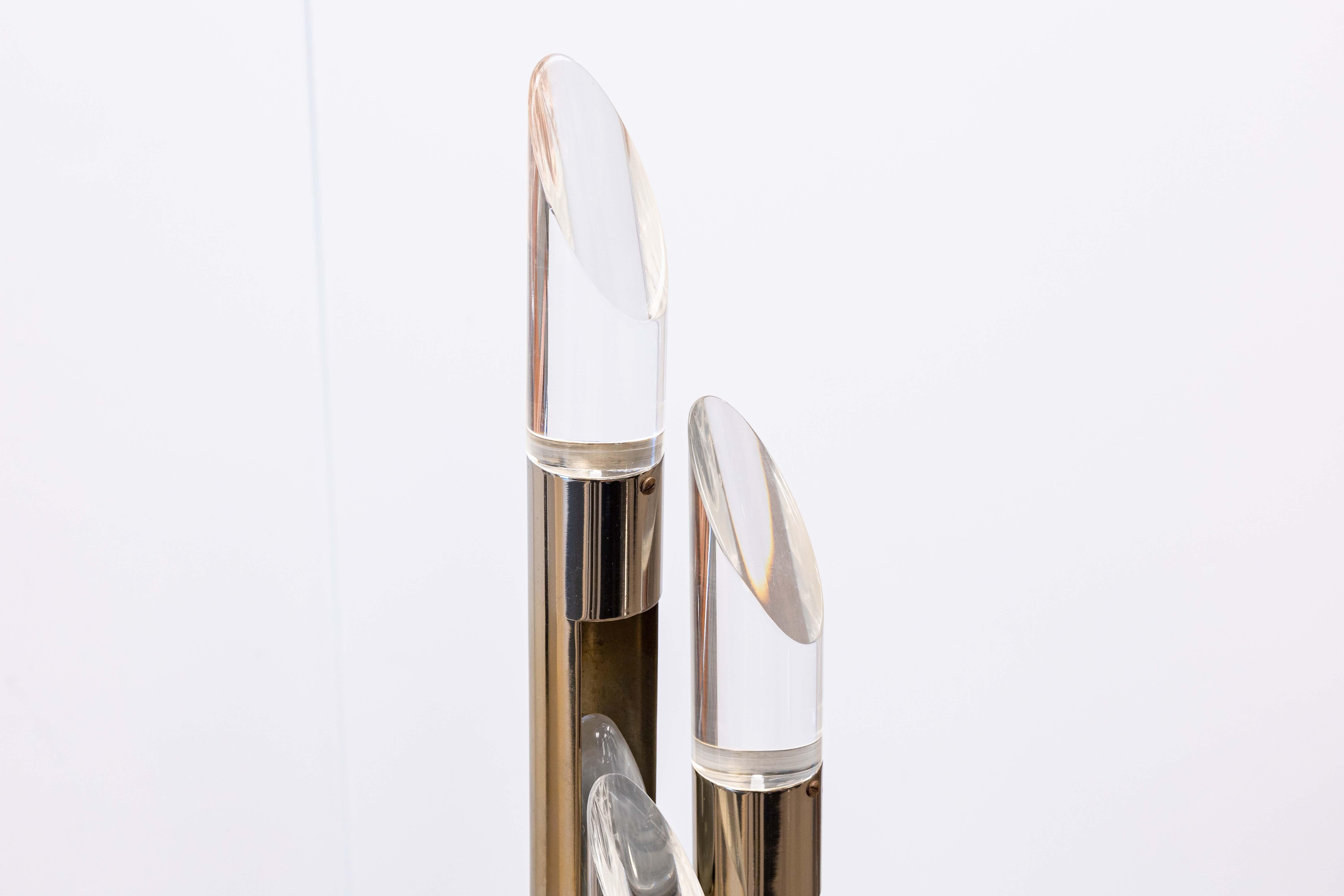 A 1970s chrome 3 fixture table lamp. This wonderful little space age style table lamp features a full chrome design. The lamp consists of a circular chrome base with three stemming lamp head fixtures sprouting from the base. Each head has a