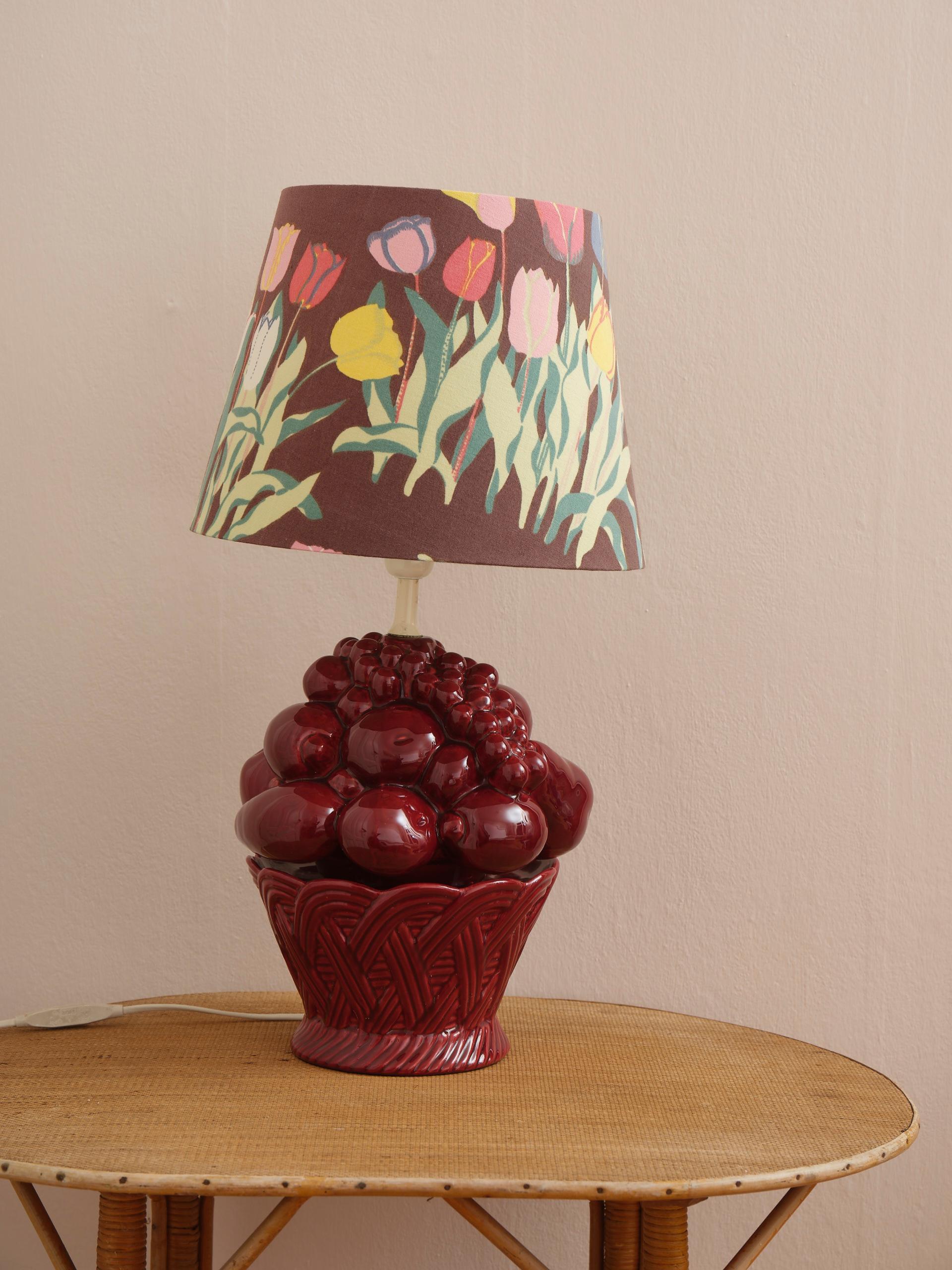 Decorative table lamp in burgundy glazed porcelain in the shape of a fruit bowl. It looks decadently Italian, but is more likely from Swedish Bofa, but who cares with this look. The lamp is shown with a handmade shade in vintage textile by Swedish