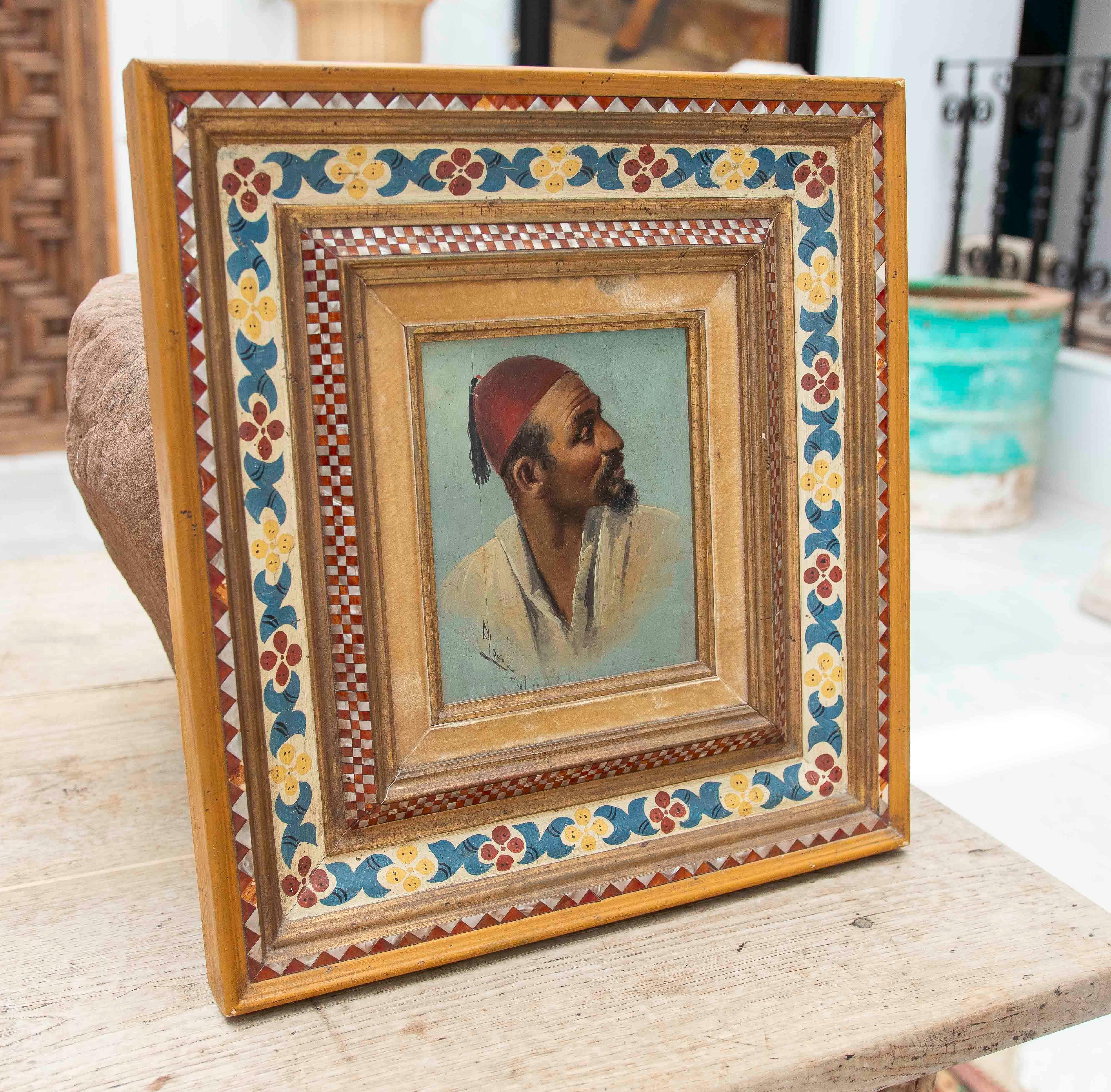 Dipinto a olio su tavola raffigurante il busto di un uomo di profilo, con barba e fez rosso, su uno sfondo azzurro. Il ritratto, firmato in basso a sinistra, si distingue per l'espressività e i dettagli del viso. L'opera è incorniciata da un ornato
