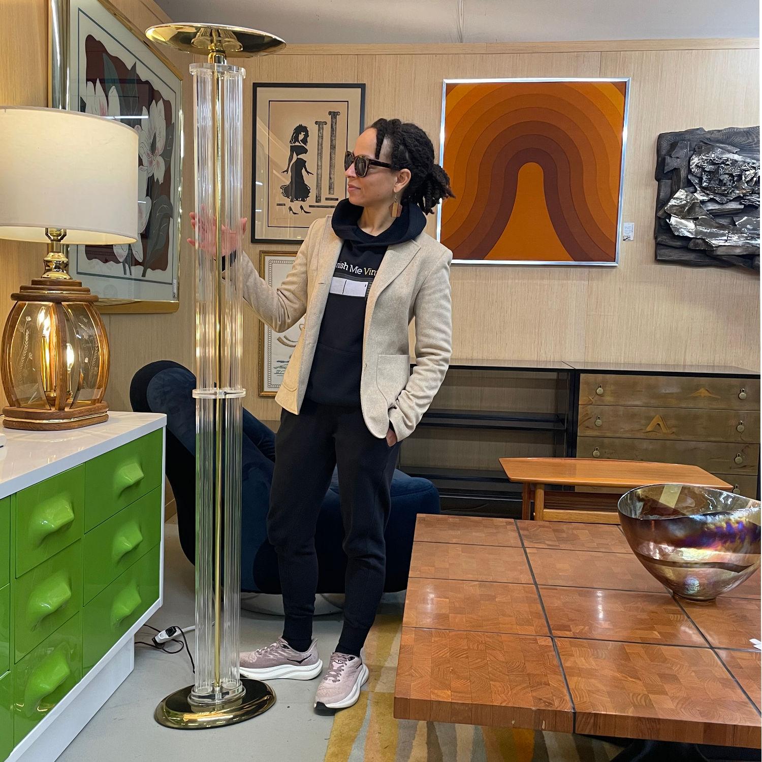 Lampadaire ultra glam d'inspiration Art déco, Nineteen-Laties, en acrylique transparent avec des accents métalliques dorés. Lorsque la pièce est chaudement éclairée, la lampe scintillante ajoute son propre éclat.La lampe en forme de colonne est