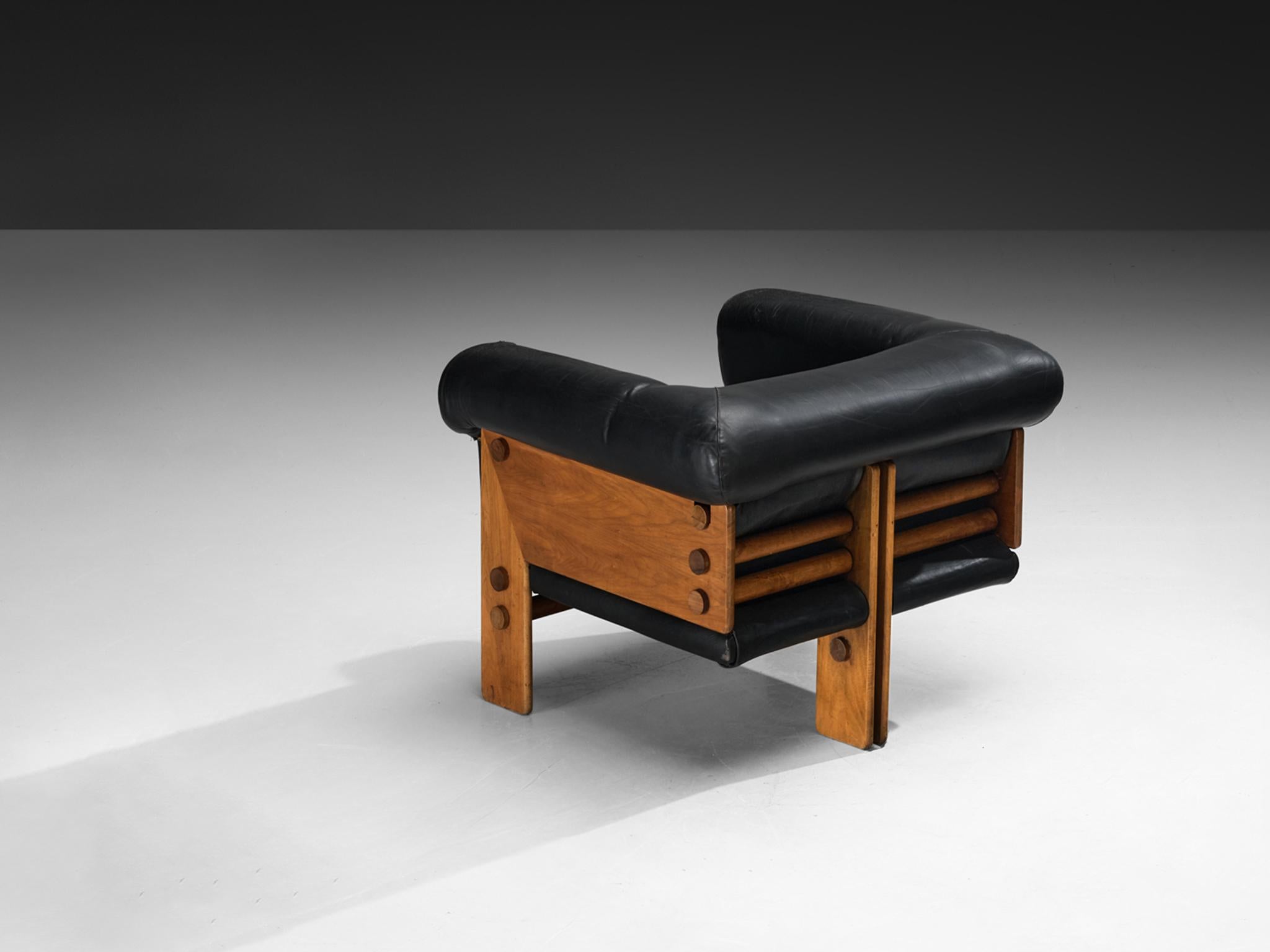 Loungesessel, Nussbaum, Leder, Europa, 1970er Jahre

Dieser bemerkenswerte Sessel zeichnet sich durch seine unverwechselbare geometrische Silhouette und sein handwerkliches Können aus. Sein Fundament ist ein dreibeiniges Gestell aus Nussbaumholz mit