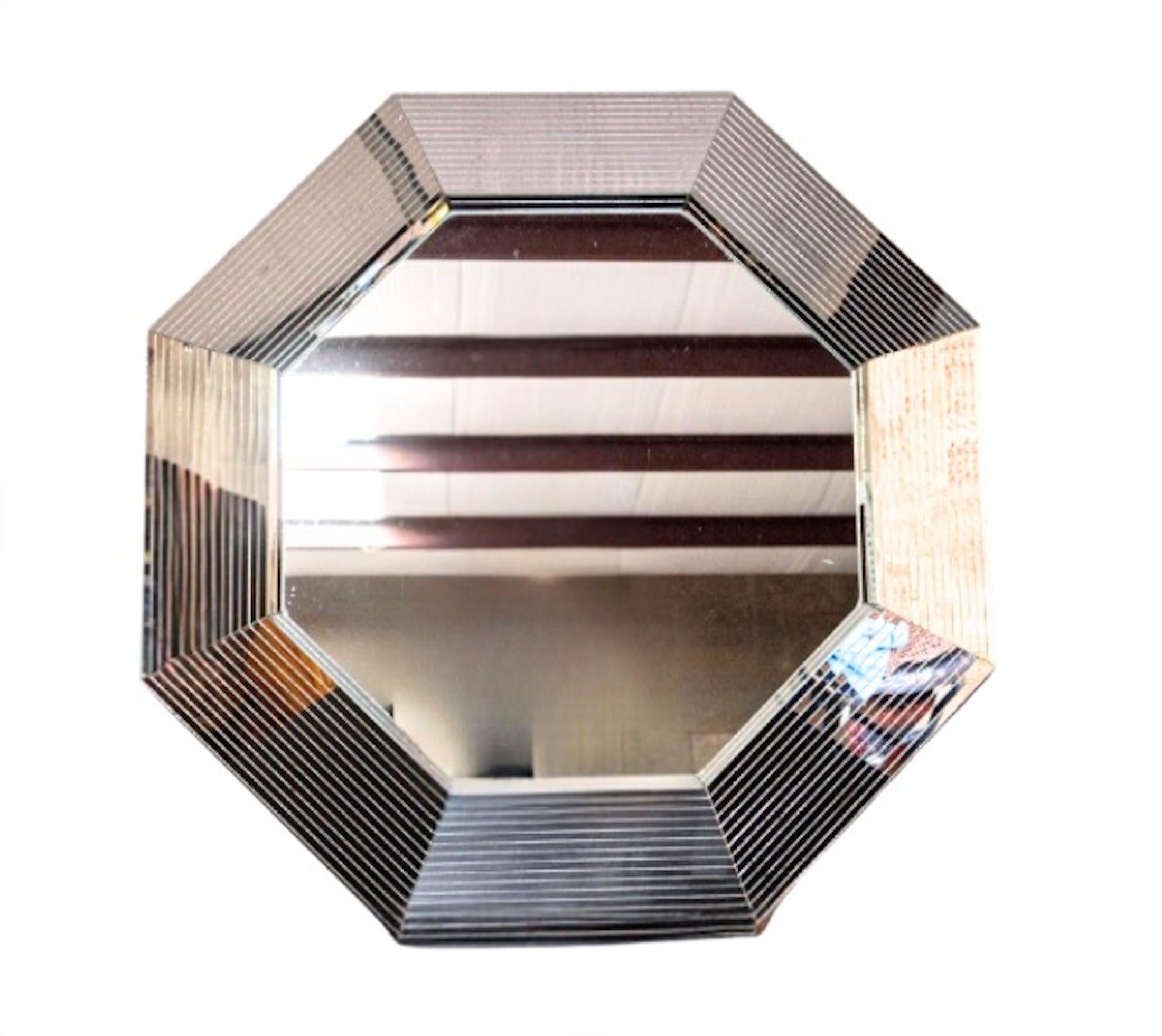 1970's Post-Modern octagonal wall mirror in the style of designer Karl Springer. it is attributed to Campbell Stoll in Brooklyn, although this mirror is missing its sticker on the back.  

The mirror is  large and catches light from all angles - the