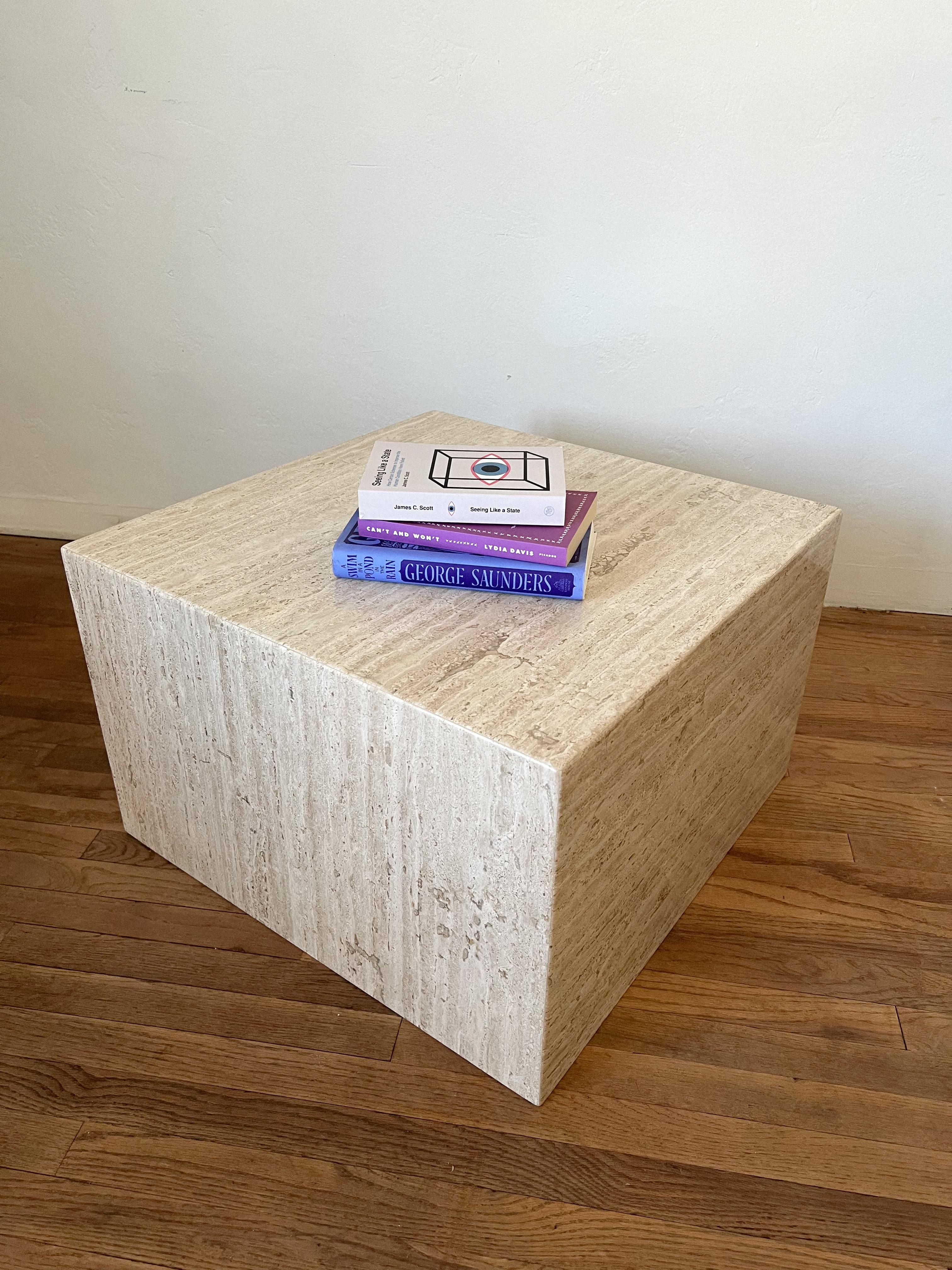 Postmodern sculptural coffee table made out of Italian honed travertine in the shape of a cube.