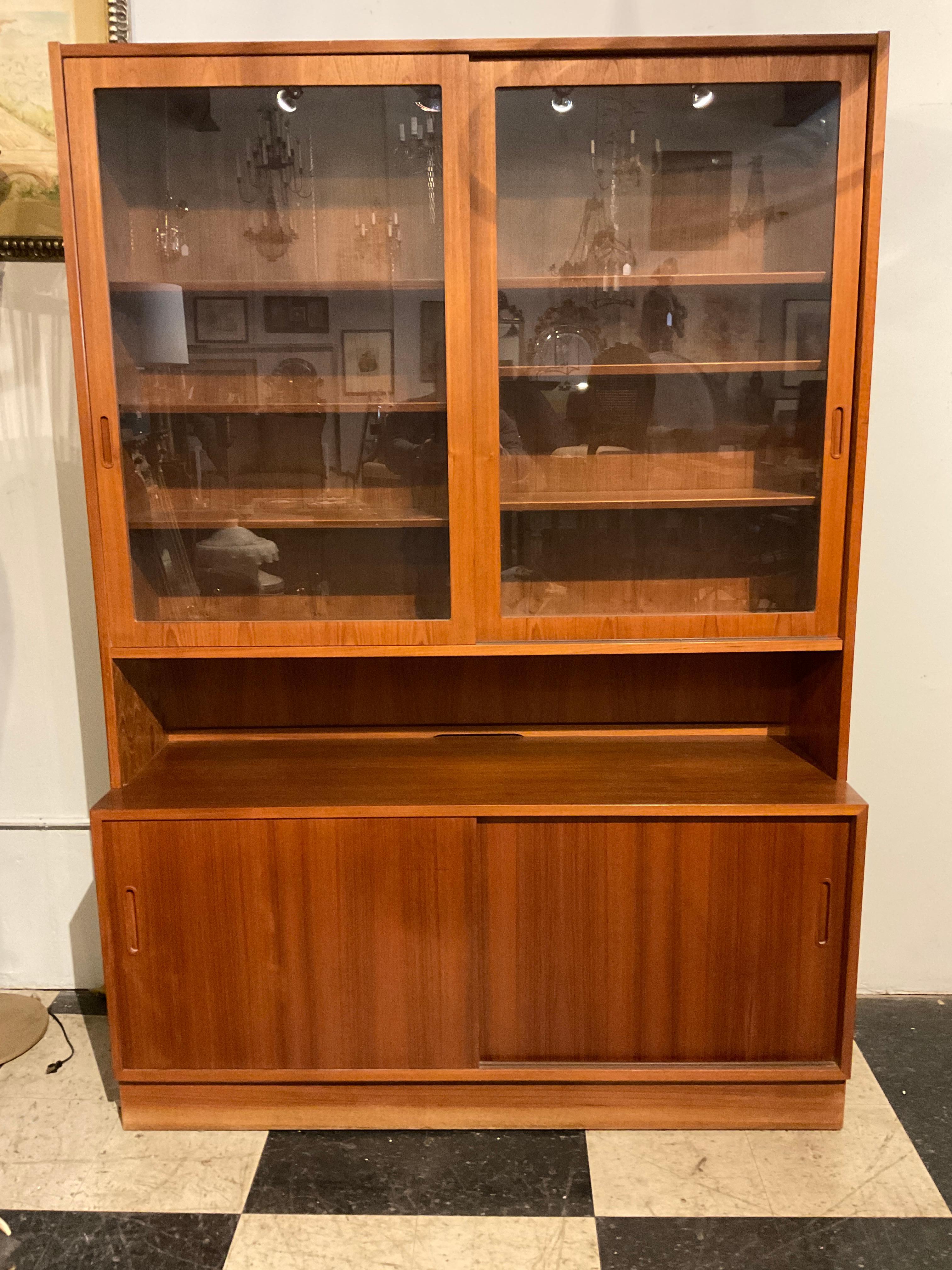 1970s  Poul Hundevad Danish teak  bookcase / china cabinet .  Glass doors. 3 Extra shelves. Scratch on door shown in picture 8. Molding  on base is faded, shown in picture 7.