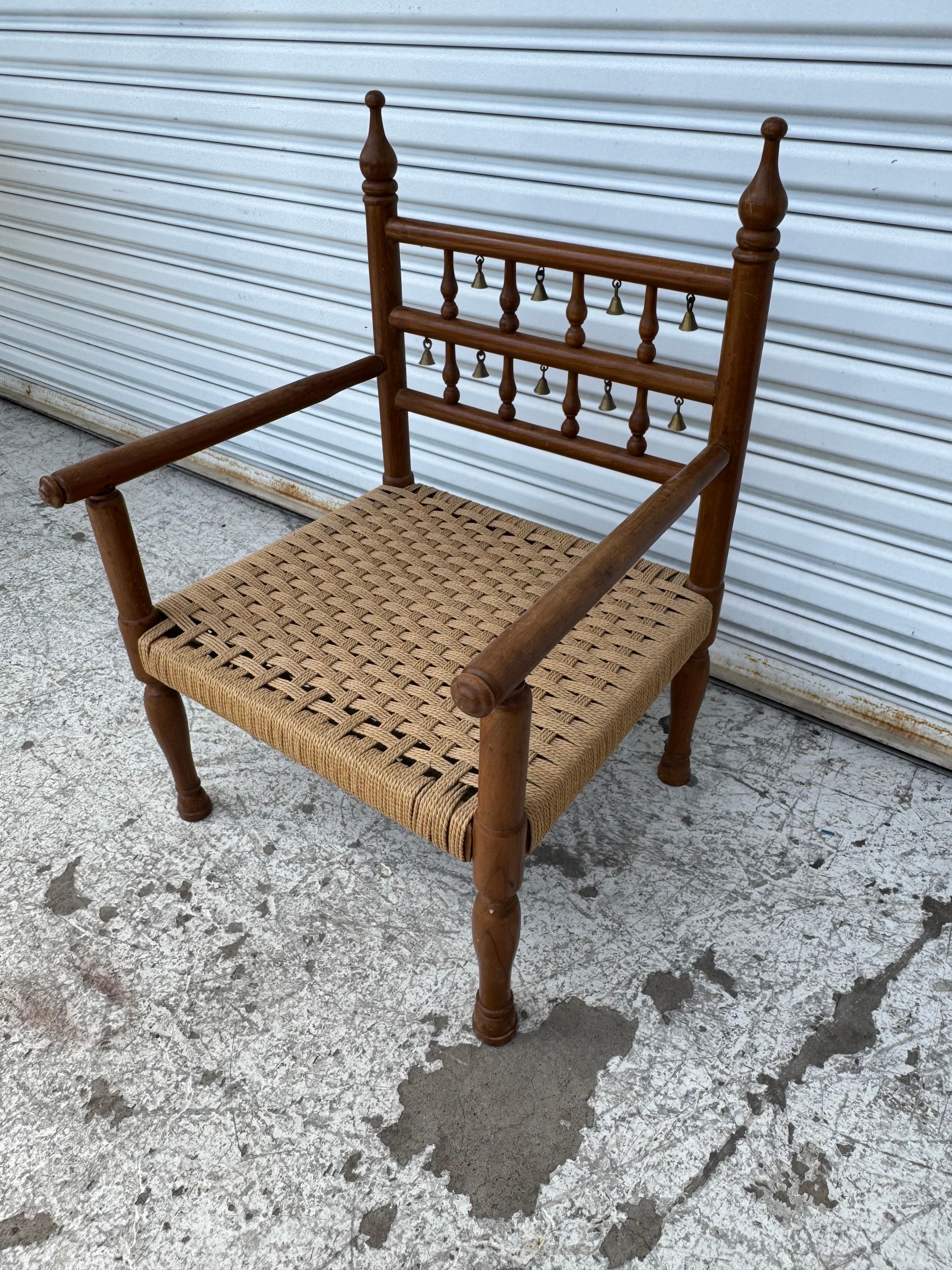 This is a Punjabi wedding chair.
It has a cord seat and brass bells on the back rest.
The chair is made of Teak.