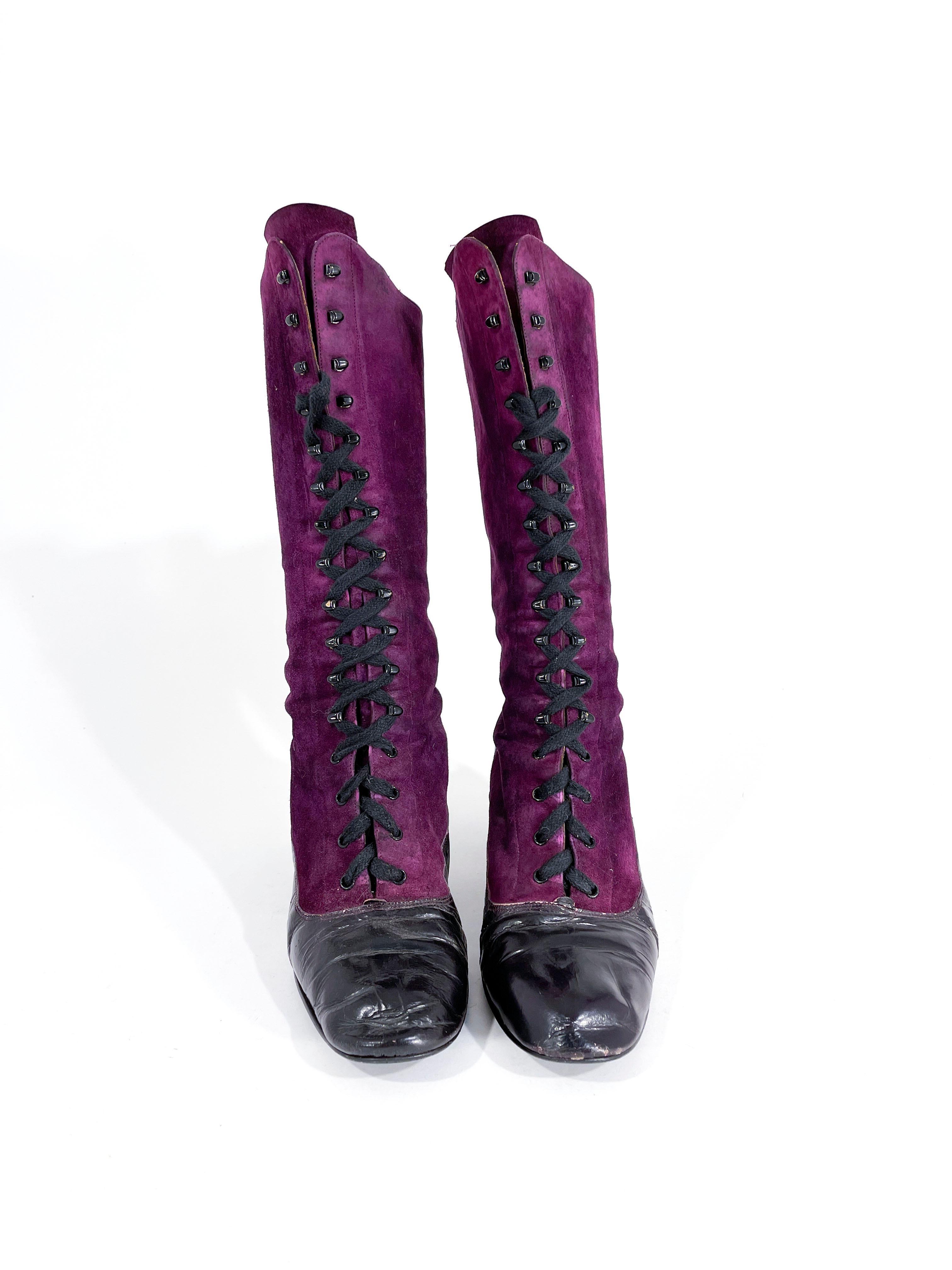 1970s purple suede and black leather Edwardian style boots that are mid-calf high. The front hat a lace up front with lace hooks and eyelets.