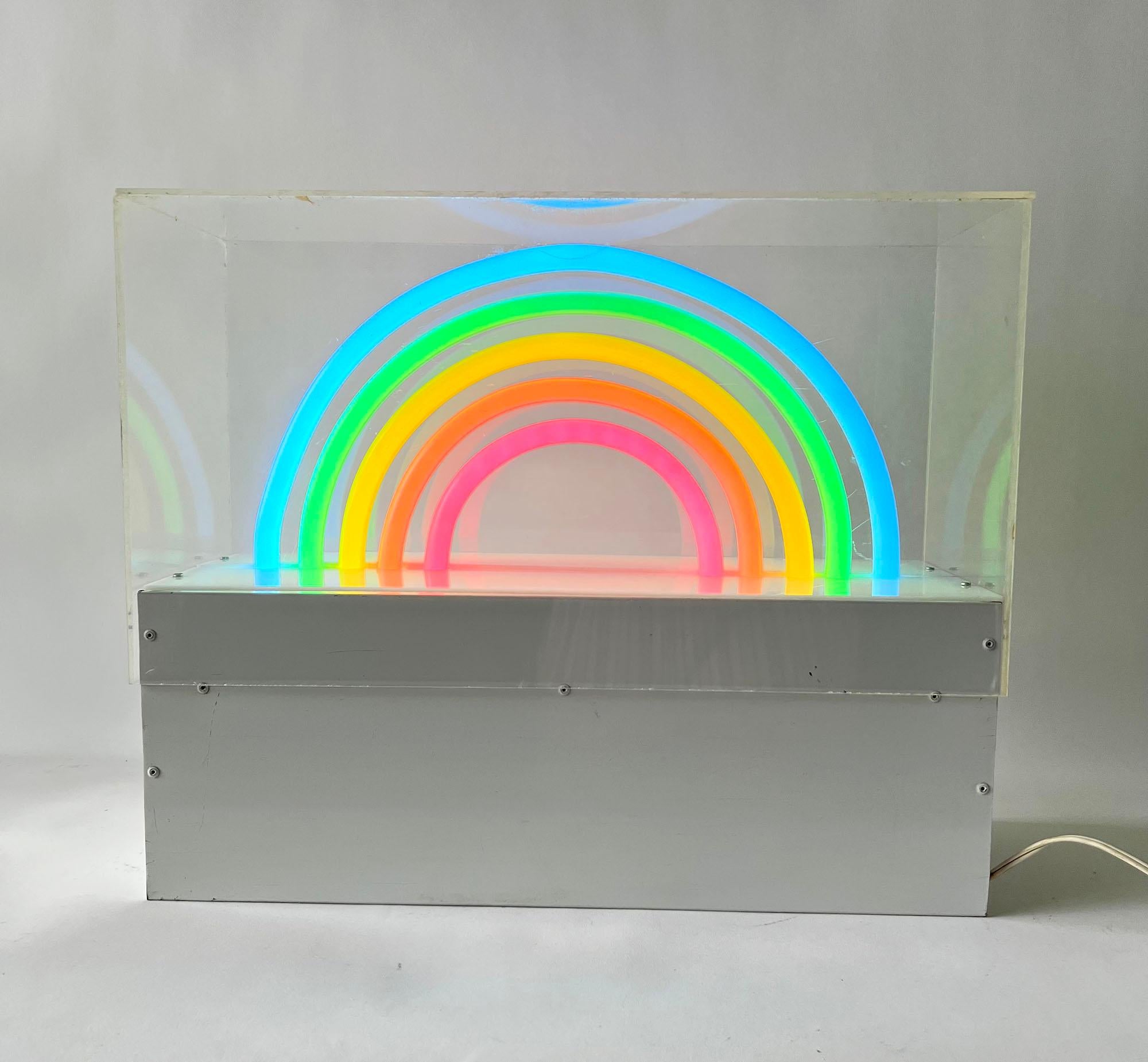 1970s or 1980s rainbow neon art plexiglass sculpture, maker unknown. First picture shows the sculpture in natural sunlight in the on position while the last picture shows it in the evening while on. The fourth thru seventh pictures give front and